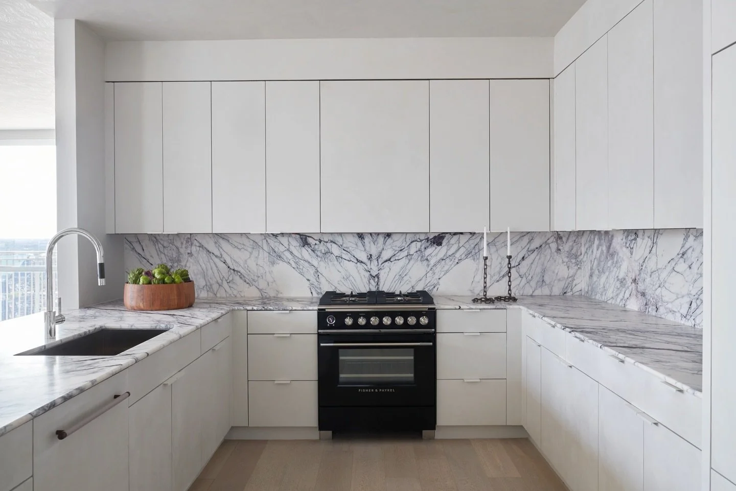 A calming sea of @portolapaints roman clay across the slab fronts, a seamless integrated vent hood, custom color matched flush pulls, and a stunning @ariastonegallery lilac marble book match for this reimagined kitchen. Captured by @hannagrankvist