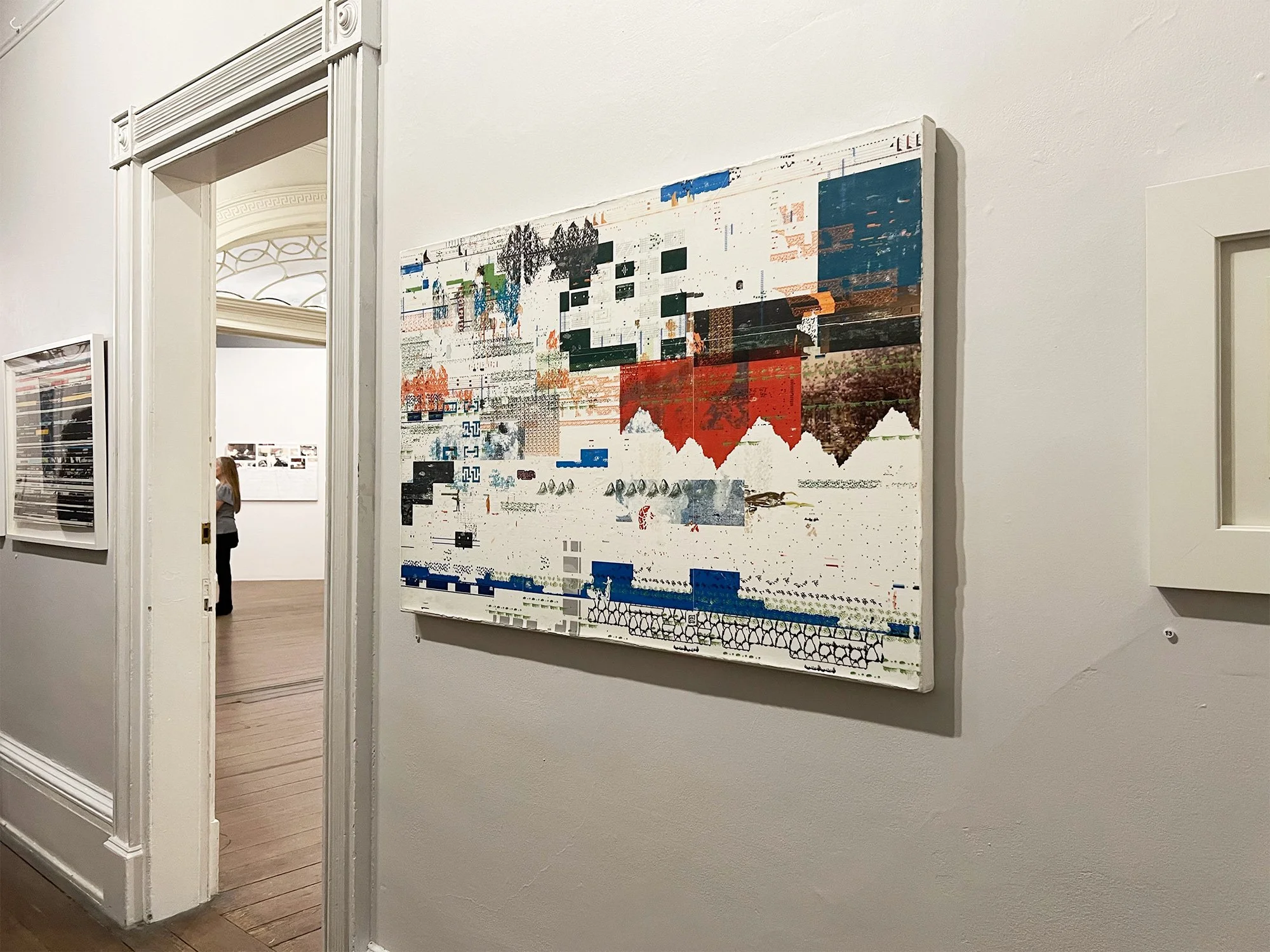 Abstract artwork with geometric shapes, color blocks, and images on a white wall in an art gallery.