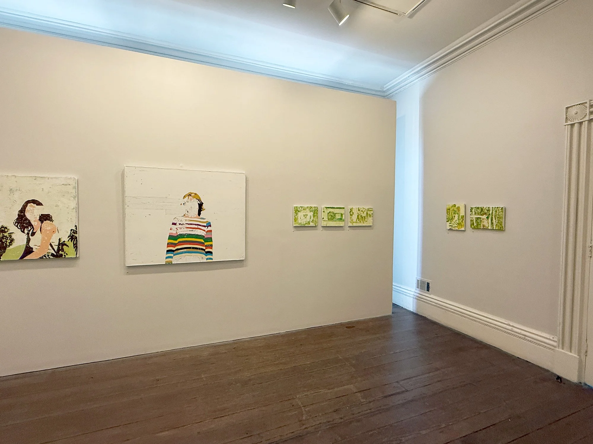 Art gallery with six paintings on white walls, wooden floor, and decorative crown molding.