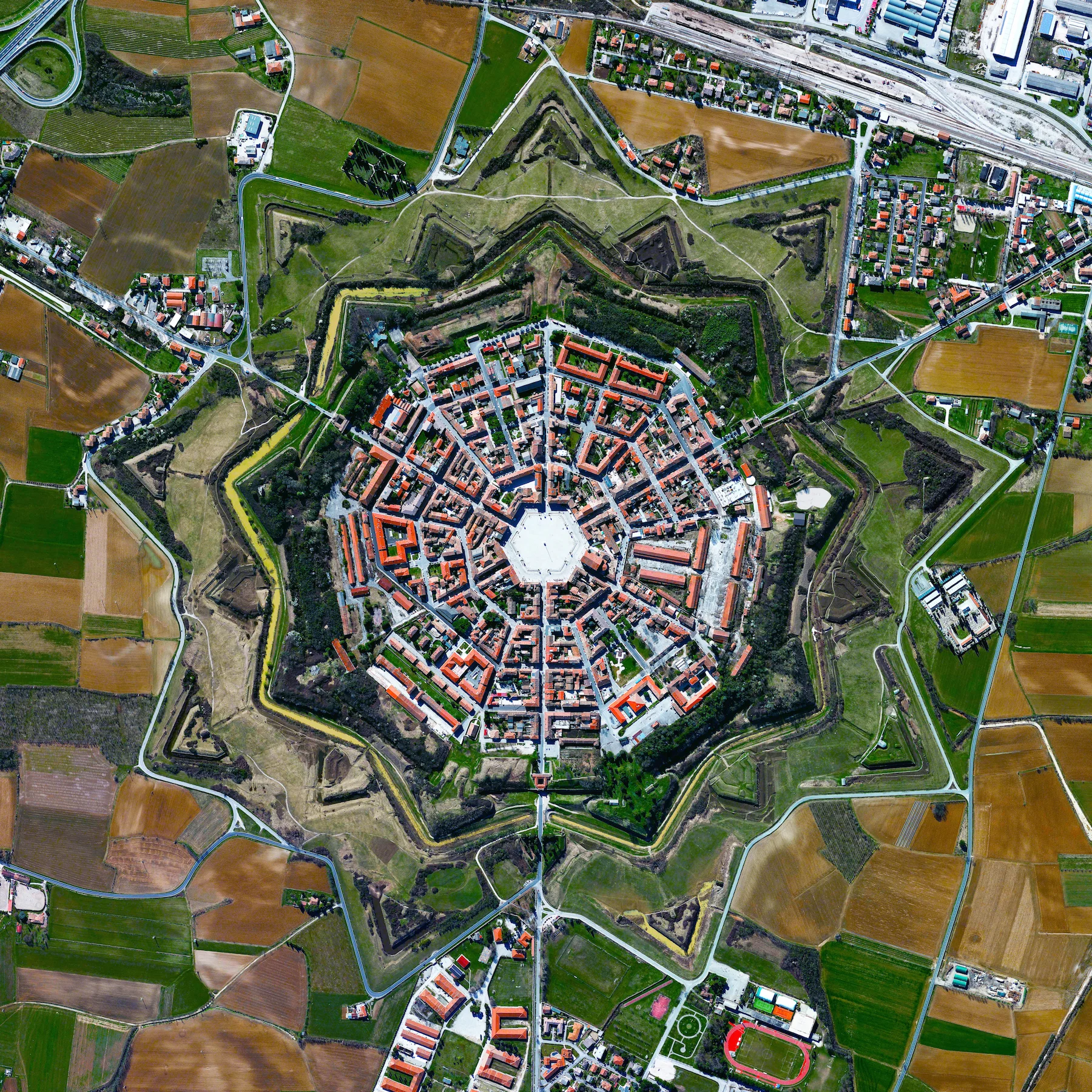11/9/2015 Palmanova Palamova, Italy 45.904892400°, 13.317671100° The town of Palmanova, Italy is recognized by its concentric layout known as a star fort. The rationale for this construction was that an attack on any individual wall could be defended from the two adjacent star points by shooting the enemy from behind. The three rings that surround Palmanova were completed in 1593, 1690, and 1813.