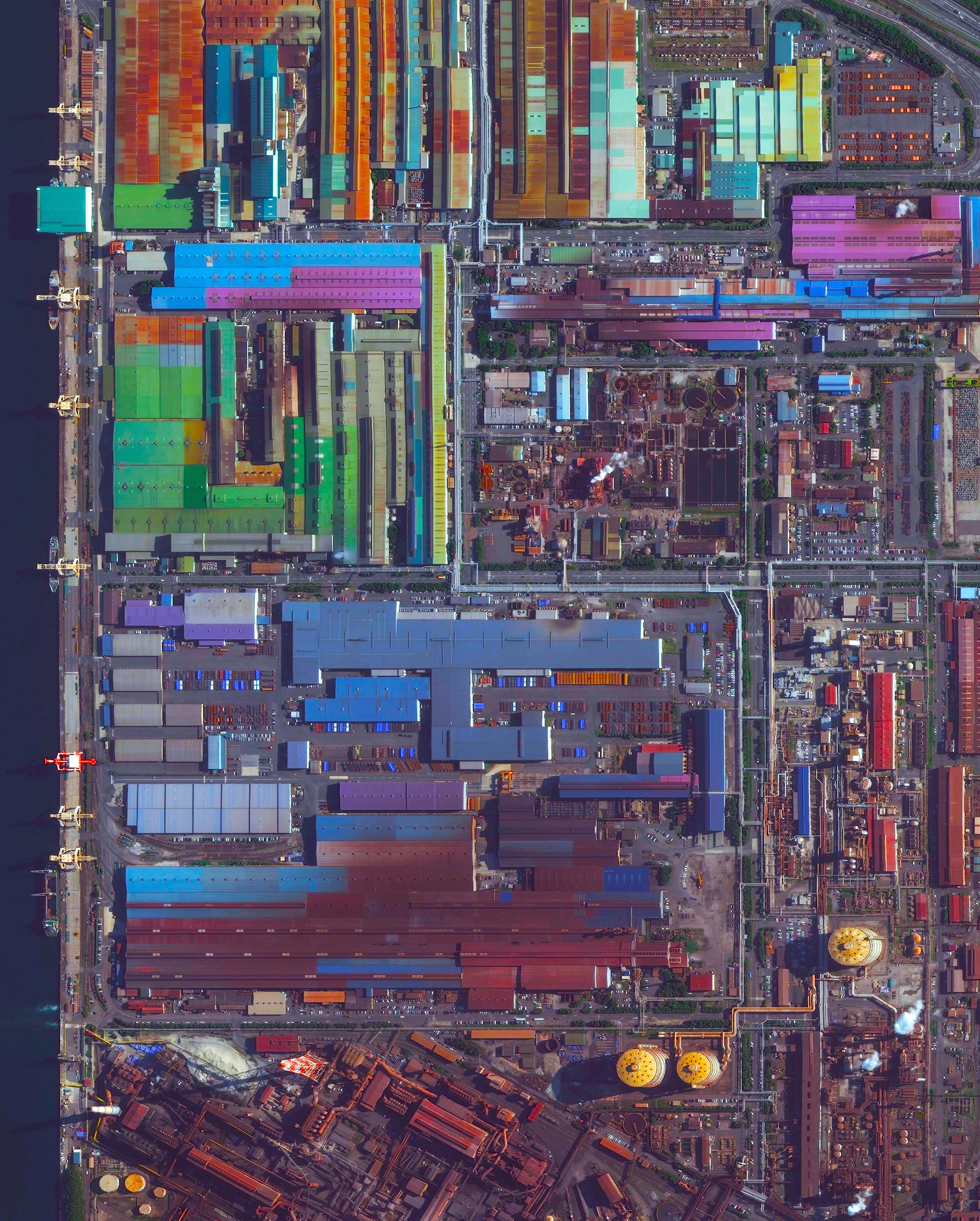 2/1/2016 Industrial buildings Tokai, Japan 35.039460°, 136.889525° Colorful, metal-roofed industrial buildings line the coast of Tokai, Japan. The city’s economy is dominated by a massive steel mill - a portion of which is seen at the bottom of this Overview. Nippon Steel, the company that owns the mill, has an annual production of more than 47 million tons of steel across its various facilities. Steels - consisting of alloys of iron and other elements, primarily carbon - is a major component in buildings, infrastructure, tools, ships, automobiles, appliances, and weapons.