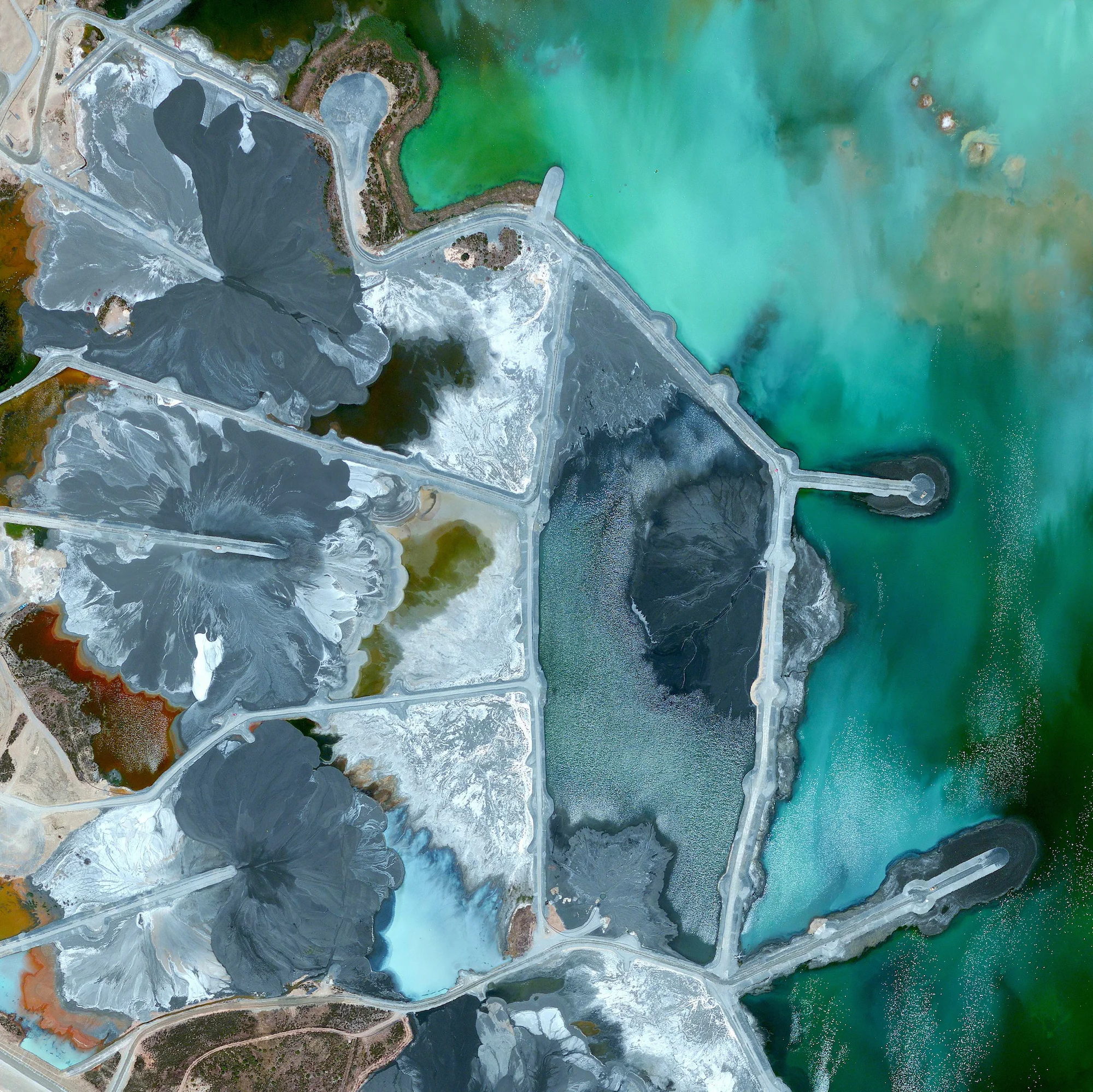 6/3/2016 Neves-Corvo Mine Castro Verde Municipality, Portugal 37°34′23″N 7°58′15″W Waste ponds are seen at the Neves-Corvo Mine in the Castro Verde Municipality in Portugal. Zinc and copper and the primary resources extracted from the mine and the byproducts of that extraction is sent to these basins three kilometers away. Typically, once waste materials are pumped into a tailings pond, they are mixed with water to create a sloppy form of mud known as slurry. The slurry is then pumped through magnetic separation chambers to extract usable ore and increase the mine’s total output.