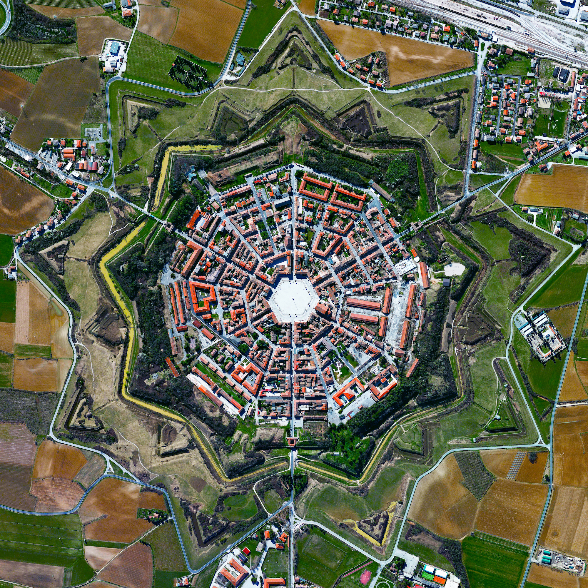 10/21/2016 Palmanova Palmanova, Italy 45.904892400°, 13.317671100° Here’s one of my favorite images from the 'Where We Design' chapter in “Overview”. The town of Palmanova, Italy is recognized by its concentric layout known as a star fort. The rationale for this construction was that an attack on any individual wall could be defended from the two adjacent star points by shooting the enemy from behind. The three rings that surround Palmanova were completed in 1593, 1690, and 1813.