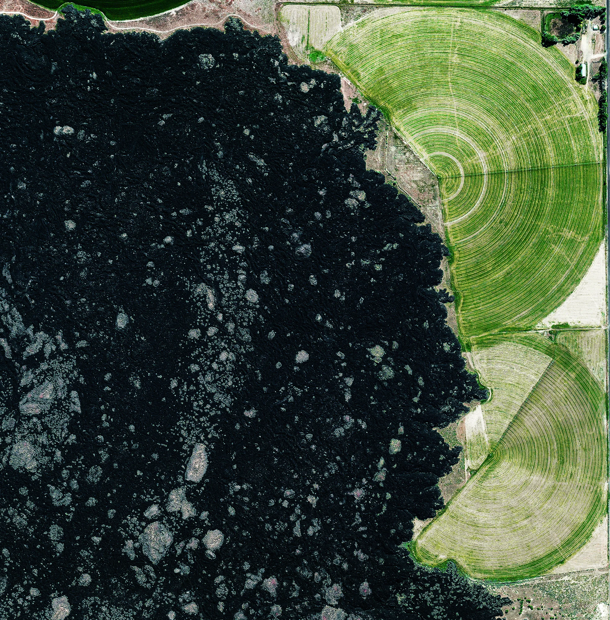 6/8/2017 Lava Field Millard County, Utah, USA 38.968922, -112.472327 Pivot irrigation fields surround a lava field known as The Cinders, in Millard County, Utah. Along with farming, one of the elements of Millard County's economy is fossil digging as Trilobite fossils are relatively common in the region west of Delta.