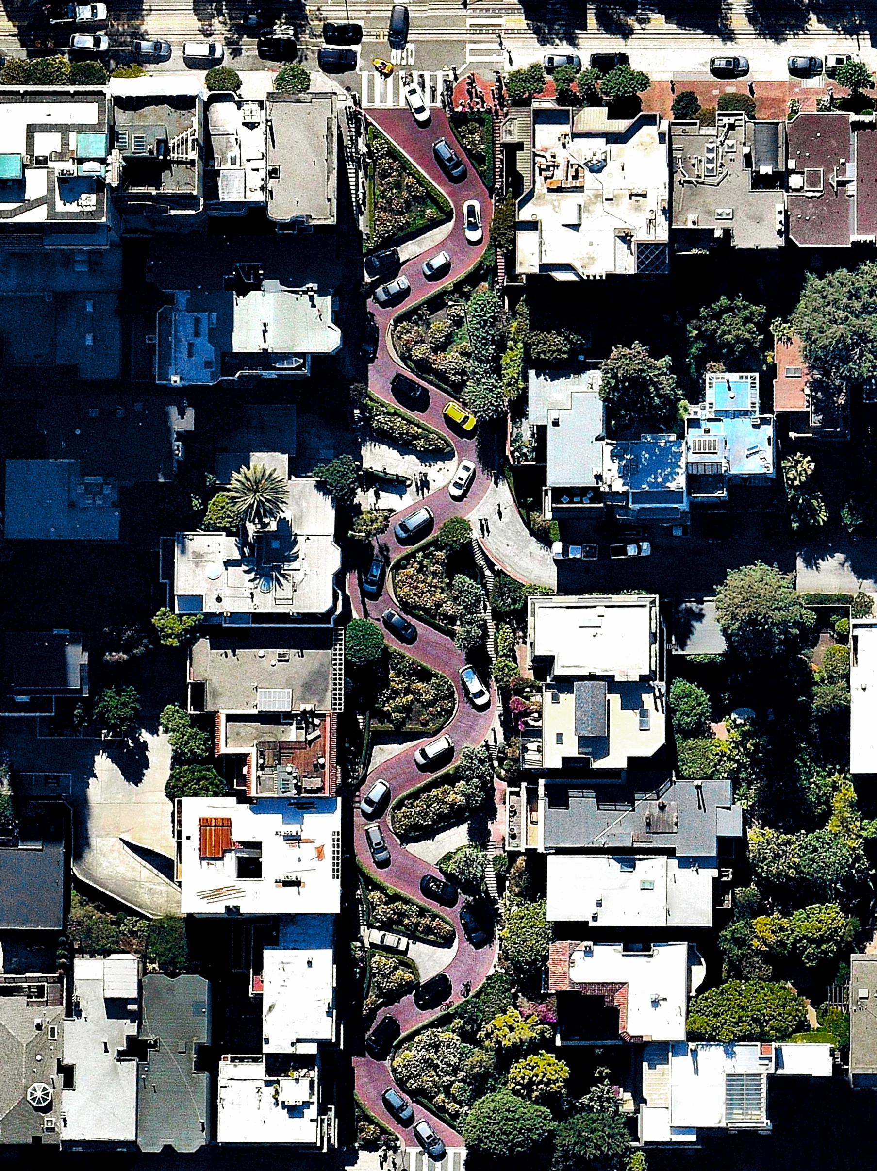 Cars wind down the hill of Lombard Street, which runs from east to west in San Francisco, California, USA. With eight hairpin turns dispersed over a one-block section in the Russian Hill neighborhood, Lombard is often referred to as “the most crooked street in the world. 37.802317, -122.419740 Source imagery: Nearmap