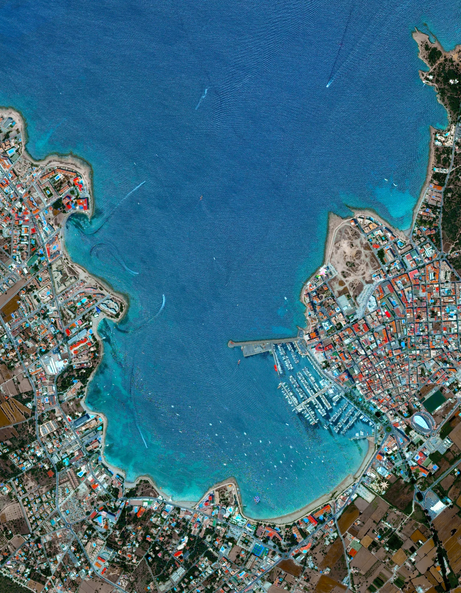 Today I am heading to Ibiza, an island located in the Mediterranean Sea off the eastern coast of Spain. Covering 572 square kilometers, Ibiza is roughly 10 times larger than the island of Manhattan in New York City. Sant Antoni de Portmany, the second largest town on the island, is seen here. 38°58′51″N 1°18′2″E