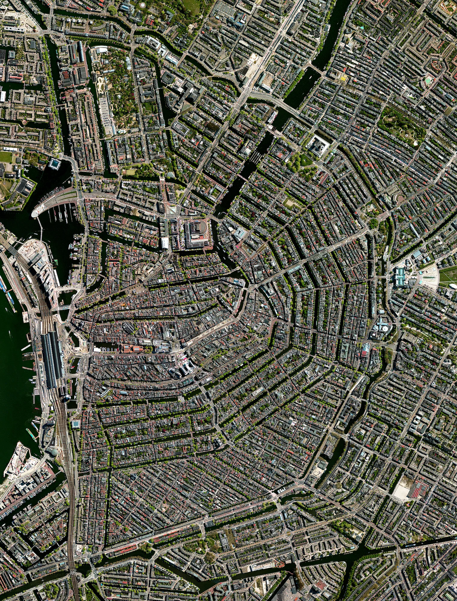 I just arrived in the beautiful city of Amsterdam, Netherlands. In the early seventeenth century, when immigration was at a peak, a comprehensive plan for the city’s expansion was developed with four concentric half-circles of canals emerging at the main waterfront (seen at the left in this Overview). In the centuries since, the canals have been used for defense, water management, and transport. They remain a hallmark of the city to this day. Hallo Amsterdam! 52° 22′ NB, 4° 54′ OL