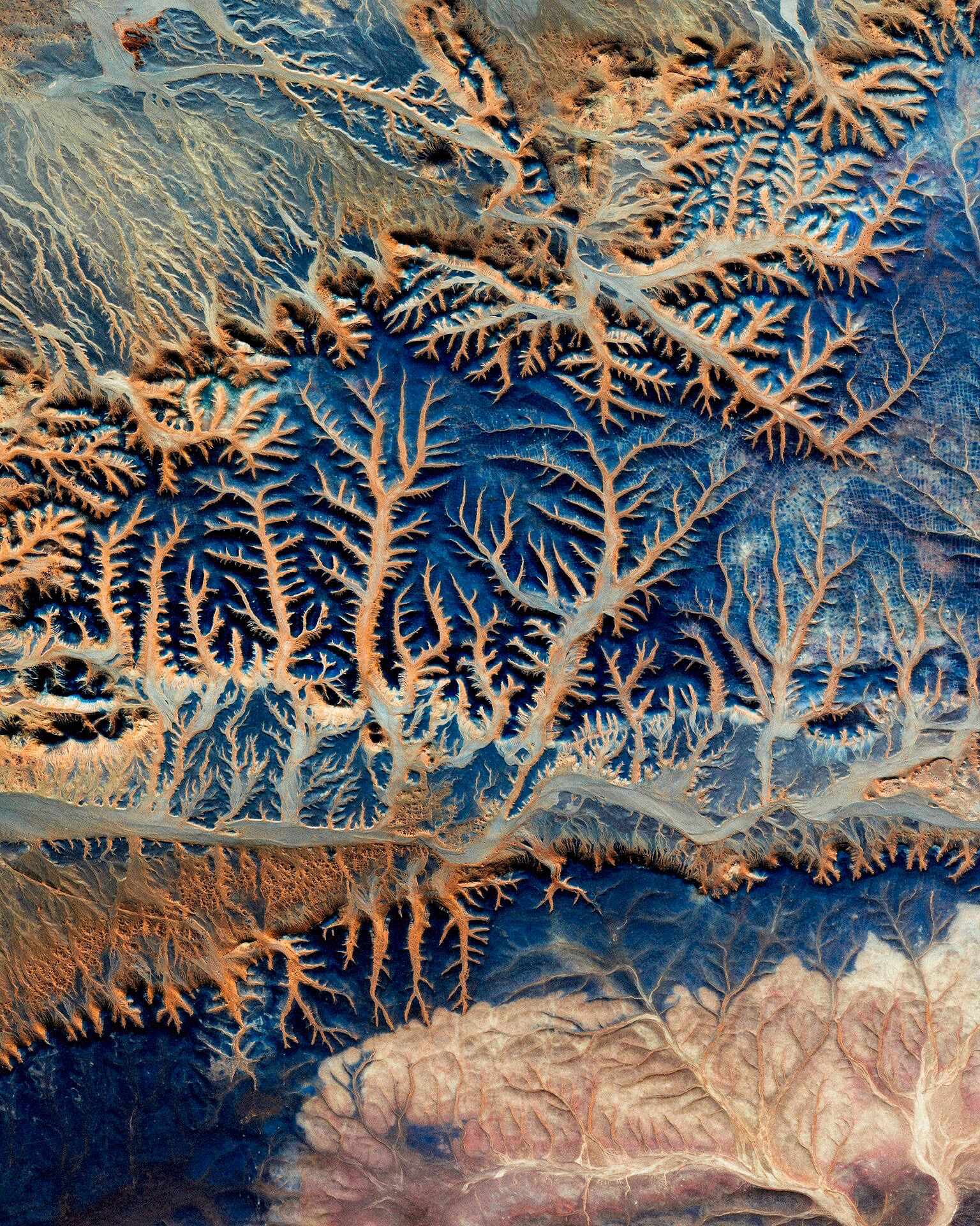 Sand dunes zigzag across the Sahara Desert in the Tiris Zemmour Region of Mauritania. Since the majority of Mauritania is covered by desert, temporary dune ranges like those in this Overview can form, disappear and reform as sands shift. Average rainfall in Tiris Zemmour is around 3.9 inches (100mm) per year. 23°46'03.4"N 7°07'52.7"W Source imagery: DigitalGlobe