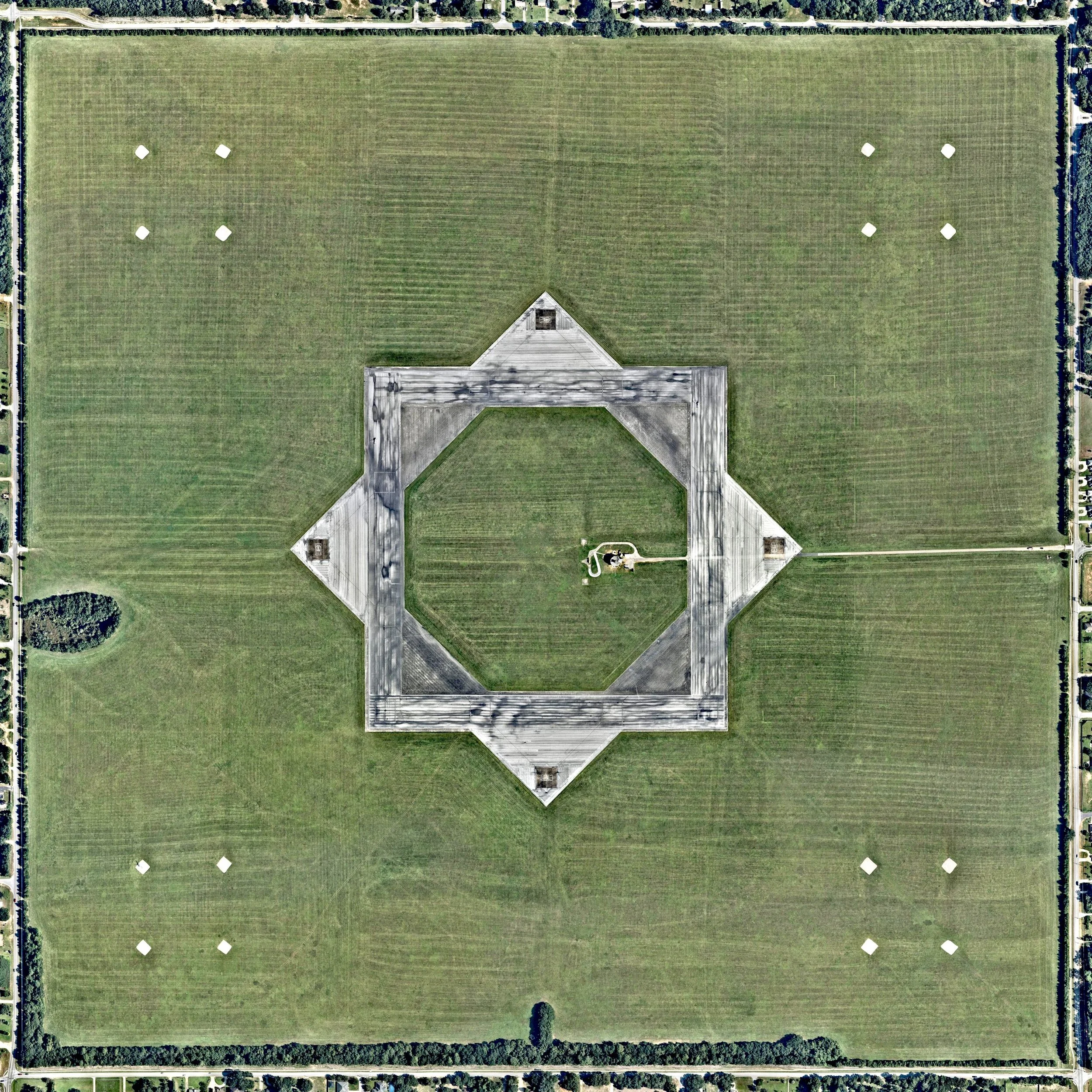 Naval Outlying Field Spencer is a military airport roughly two miles northeast of Pace, Florida, in Santa Rosa County. Centered on 640 acres, its eight equally-sized runways form two overlapping squares: one with corners pointing North, South, East and West, and another that is rotated 45 degrees. 30°37'28.8"N, 87°08'23.1"W Source imagery: Nearmap