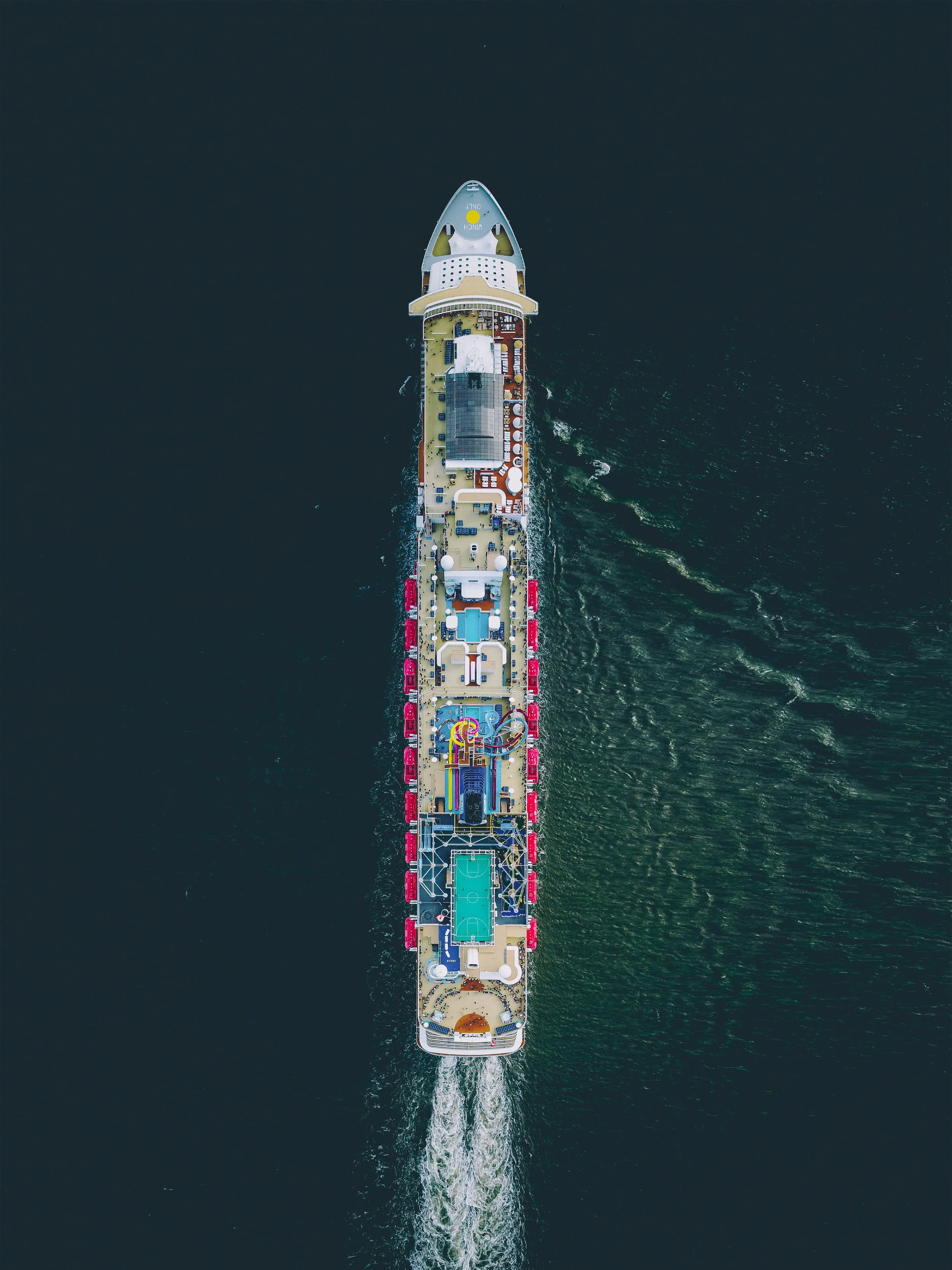 The Norwegian Breakaway cruises through the Atlantic Ocean, en route to Bermuda from New York City. This massive ship is 1,068 feet long (325 m) and has capacity for 3,963 passengers. It has 1,024 cabins, 238 suites, several bars and restaurants, a waterpark, casino, spa, and other attractions for travelers. 36°39'15.8"N, 69°29'53.9"W Source imagery: Martin Sanchez (@zekedrone)