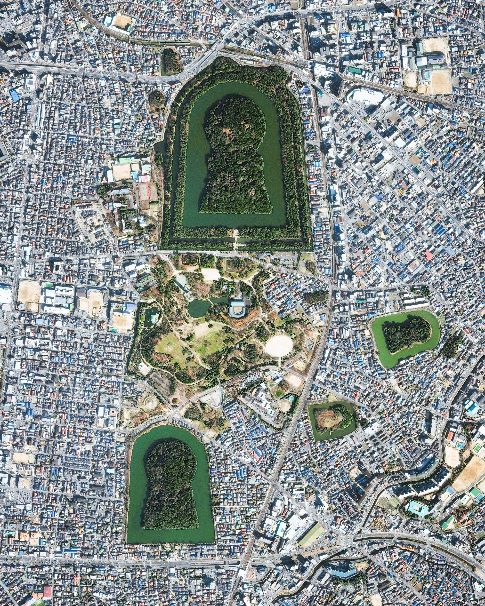 Keyhole-shaped tumuli are scattered throughout the city of Sakai in Japan's Osaka Prefecture. A tumulus is a mound of earth or stone raised over a grave, and the largest one shown in this Overview is the final resting place of Emperor Nintoku. Nearly 1,600 feet (486 m) long with a mound 115 feet (35 m) high, it covers the largest area of any tomb in the world. 34°33'45.2"N, 135°29'11.1"E Source imagery: DigitalGlobe