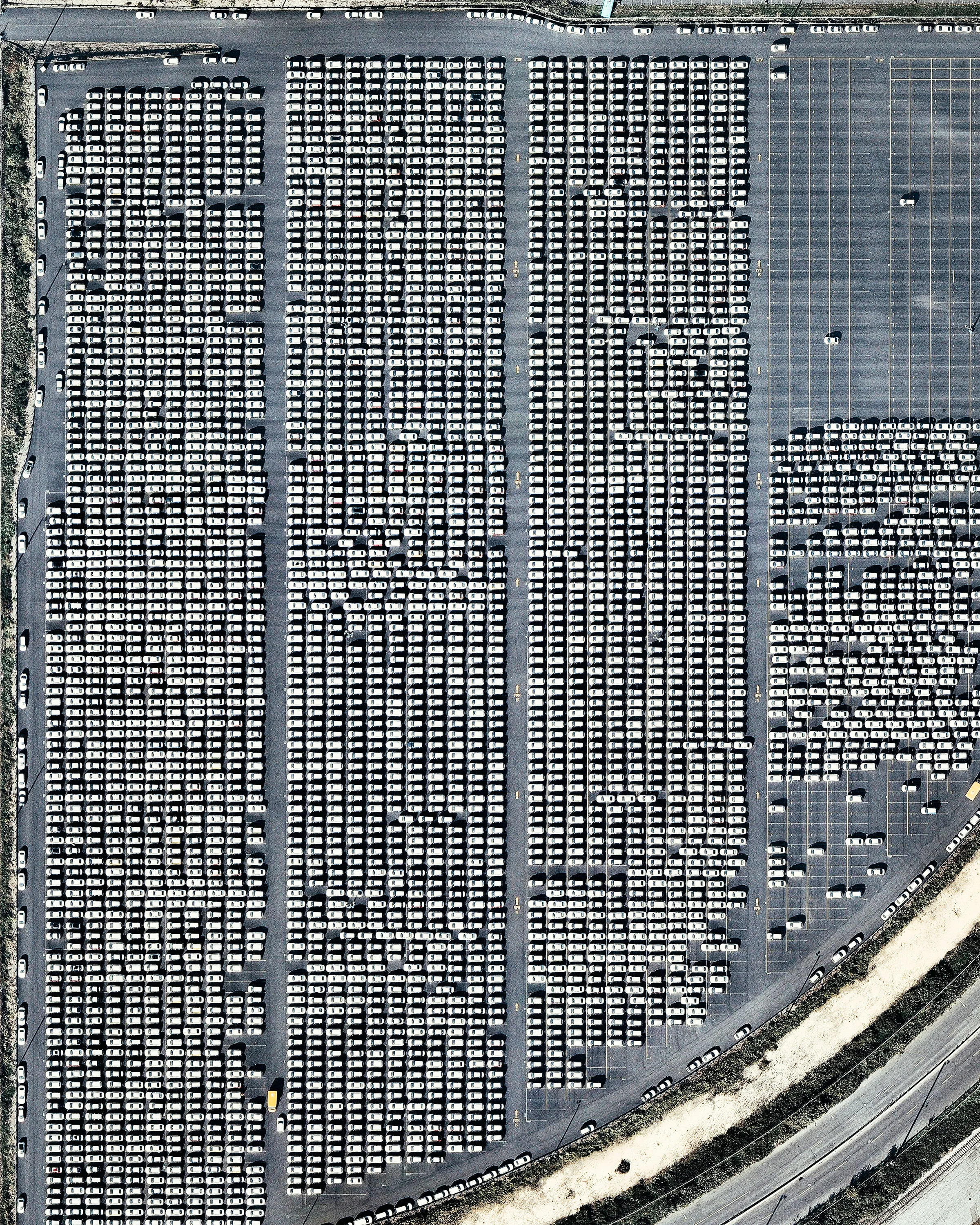 Hundreds of vehicles are parked in a processing lot near the Port of Philadelphia, Pennsylvania. Since 2010, hundreds of thousands of Hyundai and Kia vehicles have arrived at “PhilaPort” — located on the Delaware River — aboard cargo ships from South Korea. After processing, these vehicles are delivered to dealerships across the country by truck and by rail. 39°54'13.9"N, 75°08'34.6"W Source imagery: Nearmap