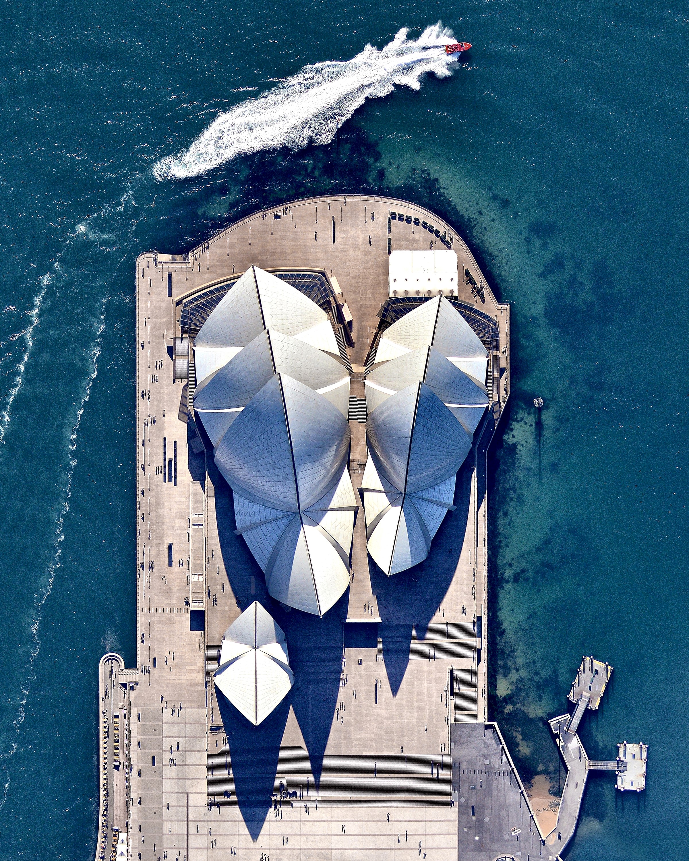 The Sydney Opera House hosts more than 1,500 shows each year in its various performance halls, drawing a total attendance of approximately 1.2 million people. While the building’s famous “shell” design appears uniformly white from a distance, it actually features a subtle chevron pattern composed of tiles in two colors: glossy white and matte cream. 33°51′31.2″S, 151°12′50.5″E Source imagery: Nearmap