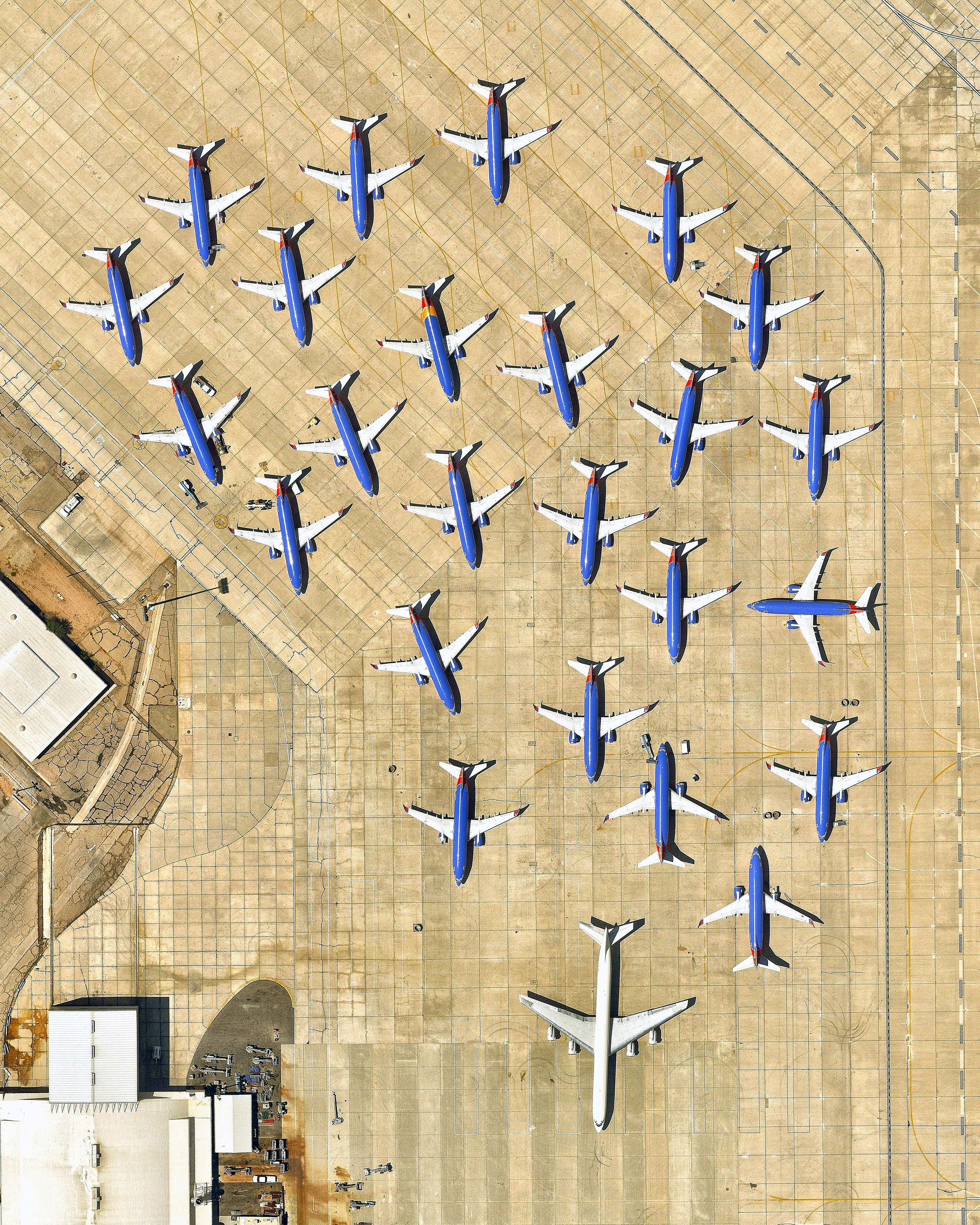 In this Overview, 25 airplanes are parked in a cluster at the Southern California Logistics Airport in Victorville, California. Also known as Victorville Airport, it is home to Southern California Aviation, a large transitional facility for commercial aircraft. No commercial passenger services are offered at the airport except for fixed-based operator and charter flights. 34°35'51.0"N, 117°22'59.0"W Source imagery: Nearmap