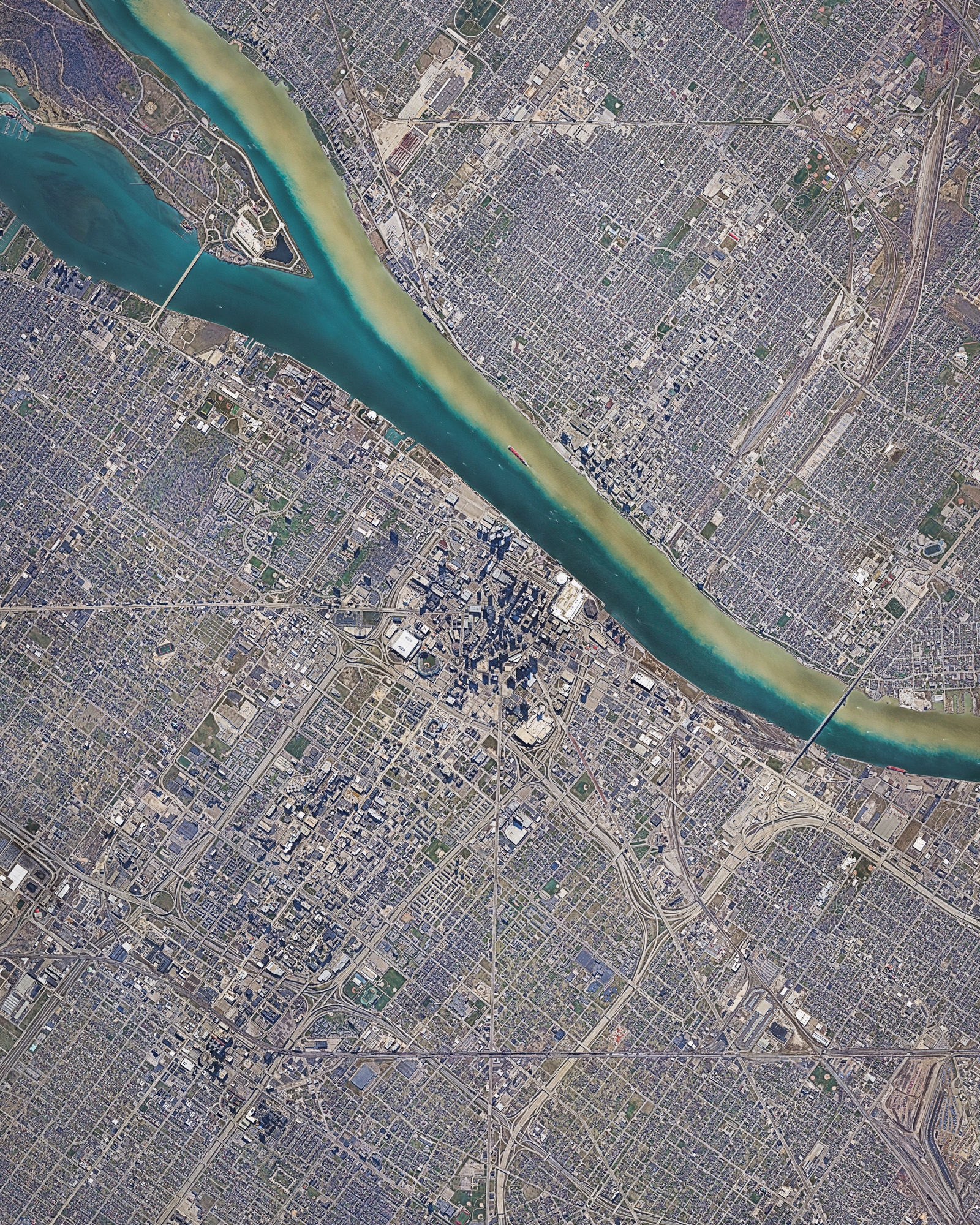 Detroit is the largest and most populous city in the state of Michigan, with 4.3 million residents in its metropolitan area. It is best known as the center of the U.S. automobile industry, housing the headquarters of General Motors, Ford and Chrysler. Detroit is also a major port on the Detroit River, which is shown flowing through the city in this Overview — does anyone know why the river has two shades? 42°19'53.0"N, 83°02'45.0"W Source imagery: Nearmap