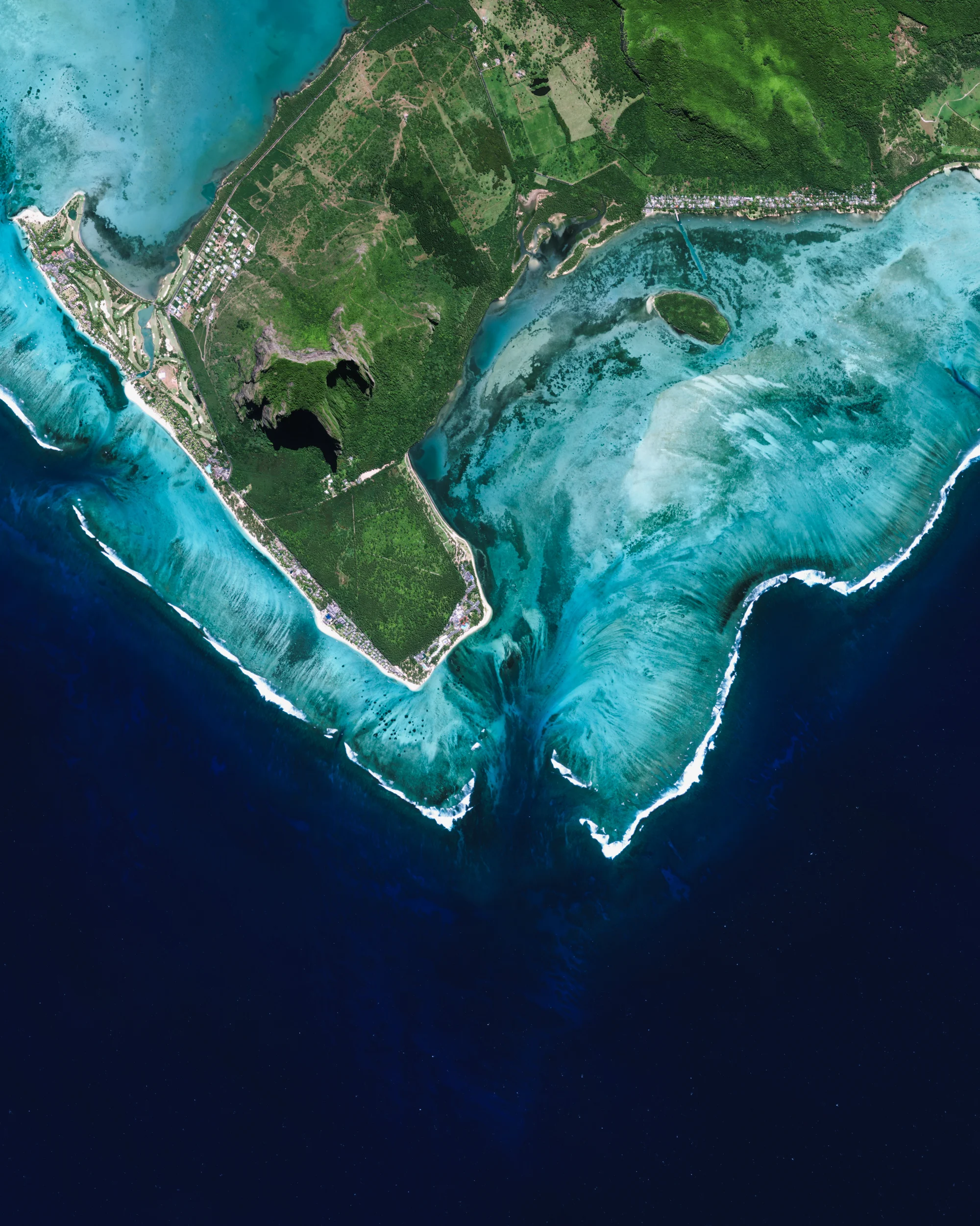 Just off the southwestern corner of Mauritius (shown at the center of this Overview) is what appears to be an underwater waterfall. In reality, it is just the flow of underwater currents and sand patterns on the ocean floor that form this spectacular optical illusion from the aerial perspective. Mauritius is an island nation in the Indian Ocean, roughly 1,200 miles (2,000 km) off the southeastern coast of Africa. 20°28'23.9"S, 57°18'33.3"E Source imagery: DigitalGlobe