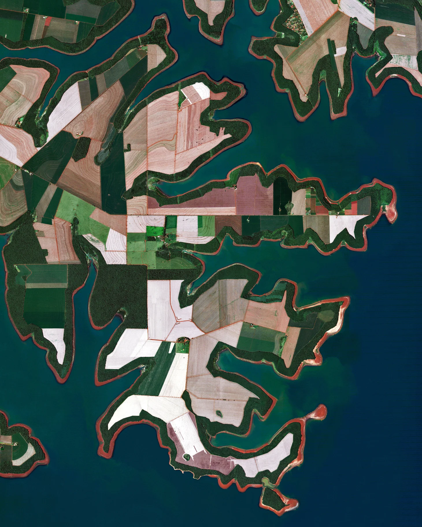 Agricultural fields line the shores of the Itaipu Reservoir — a body of water that forms the border between Brazil and Paraguay. The area’s tropical climate makes it an ideal place to grow sugarcane, coffee, tea, and cotton. 25°18'20.3"S, 54°25'12.6"W Source imagery: DigitalGlobe