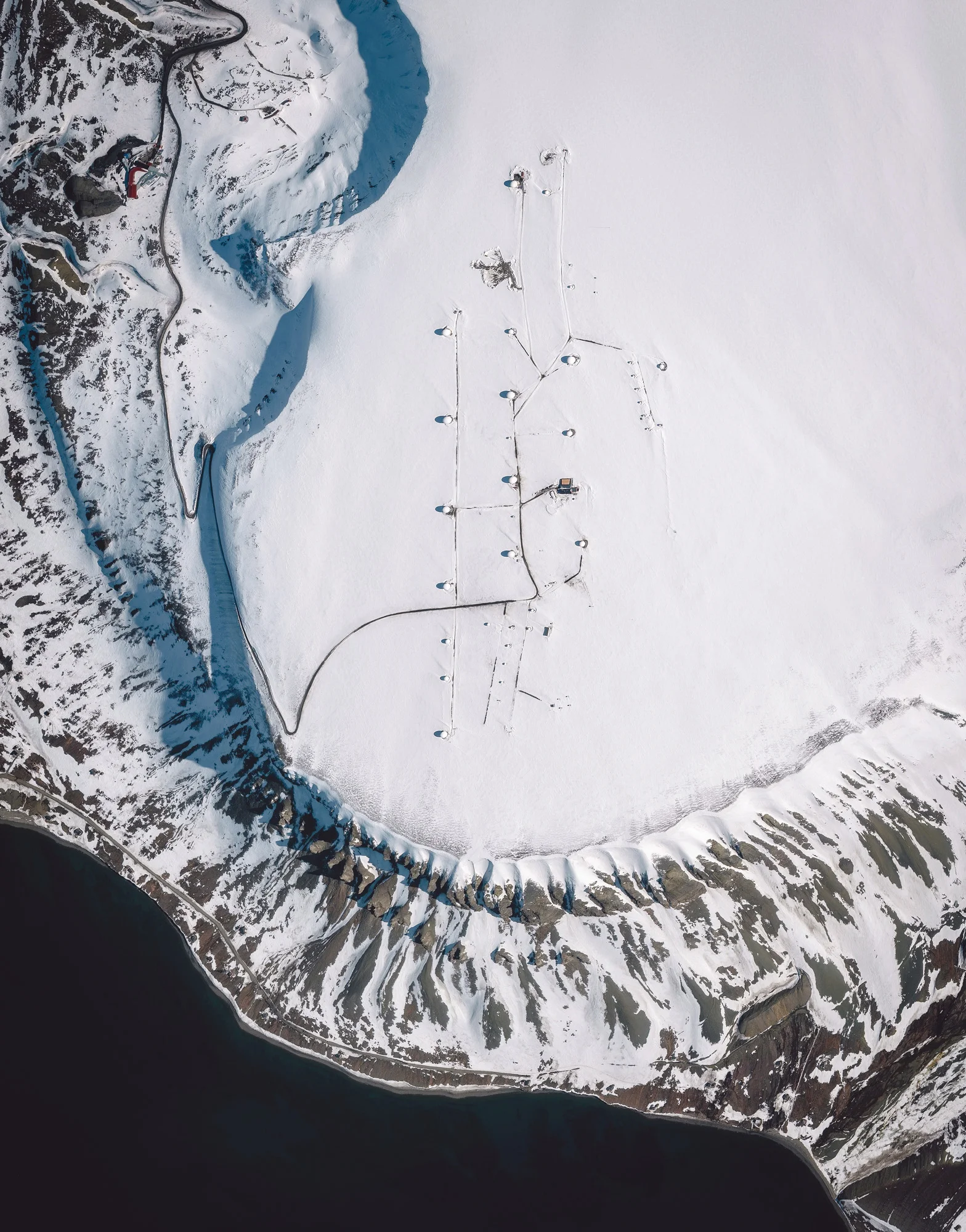 Svalbard Satellite Station, also known as SvalSat, is a satellite ground station near Longyearbyen, Svalbard, Norway. Its position on the 78th parallel north makes it advantageous for communication with satellites in low polar orbits. SvalSat has 31 multi-mission and customer-dedicated antennas, serving clients like NASA, the European Space Agency, National Oceanic and Atmospheric Administration (NOAA), and others. 78°13'47.2"N, 15°24'28.0"E Source imagery: DigitalGlobe