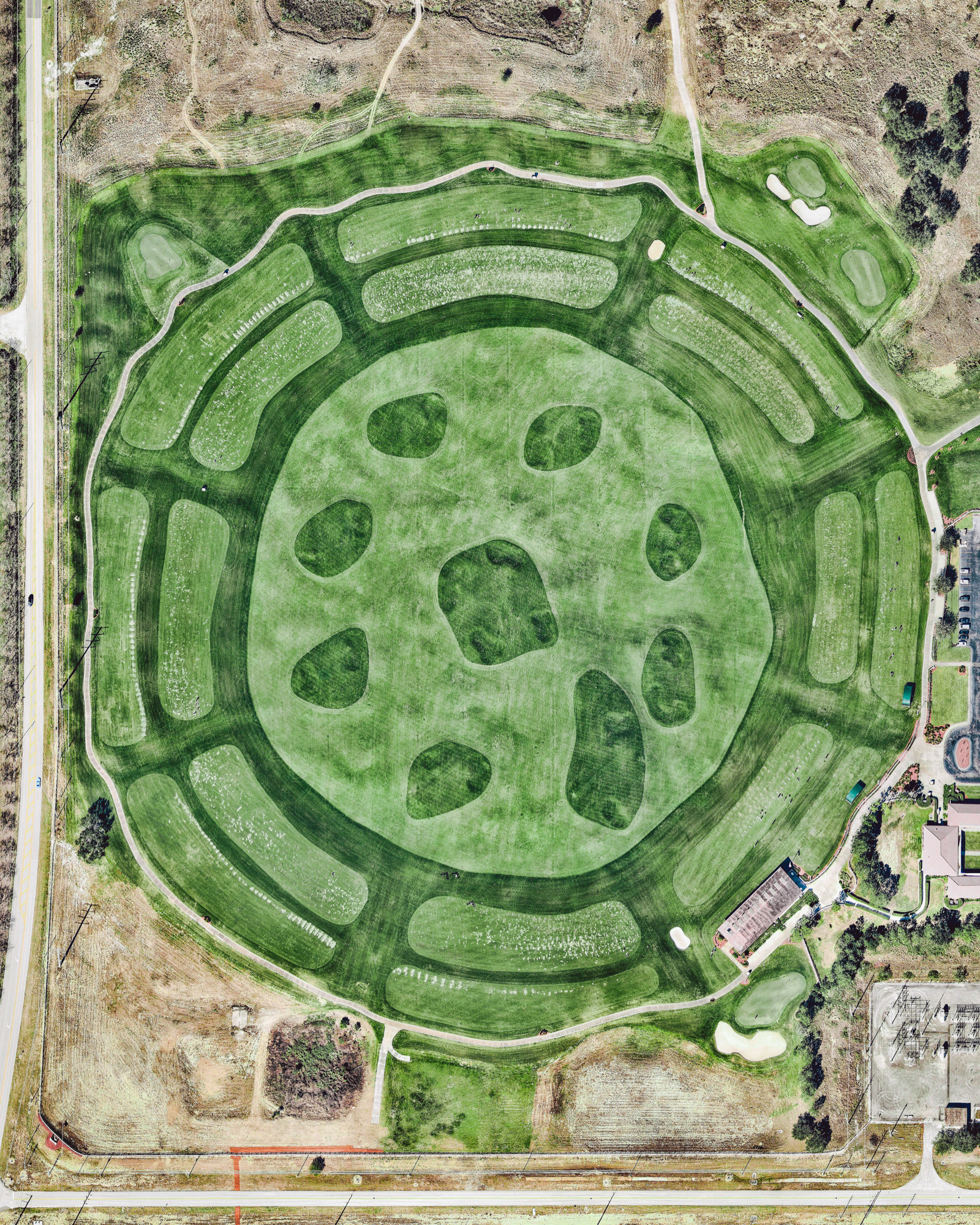 A large circular driving range is seen here at the Orange County National Golf Center and Lodge in Winter Garden, Florida. Including putting greens and a short-game practice area, the facility covers 42 acres (17 hectares). It is visited by many golf professionals every year; in fact, Tiger Woods once used the driving range to film a commercial with Nike. 28°26'38.9"N, 81°38'01.3"W Source imagery: Nearmap