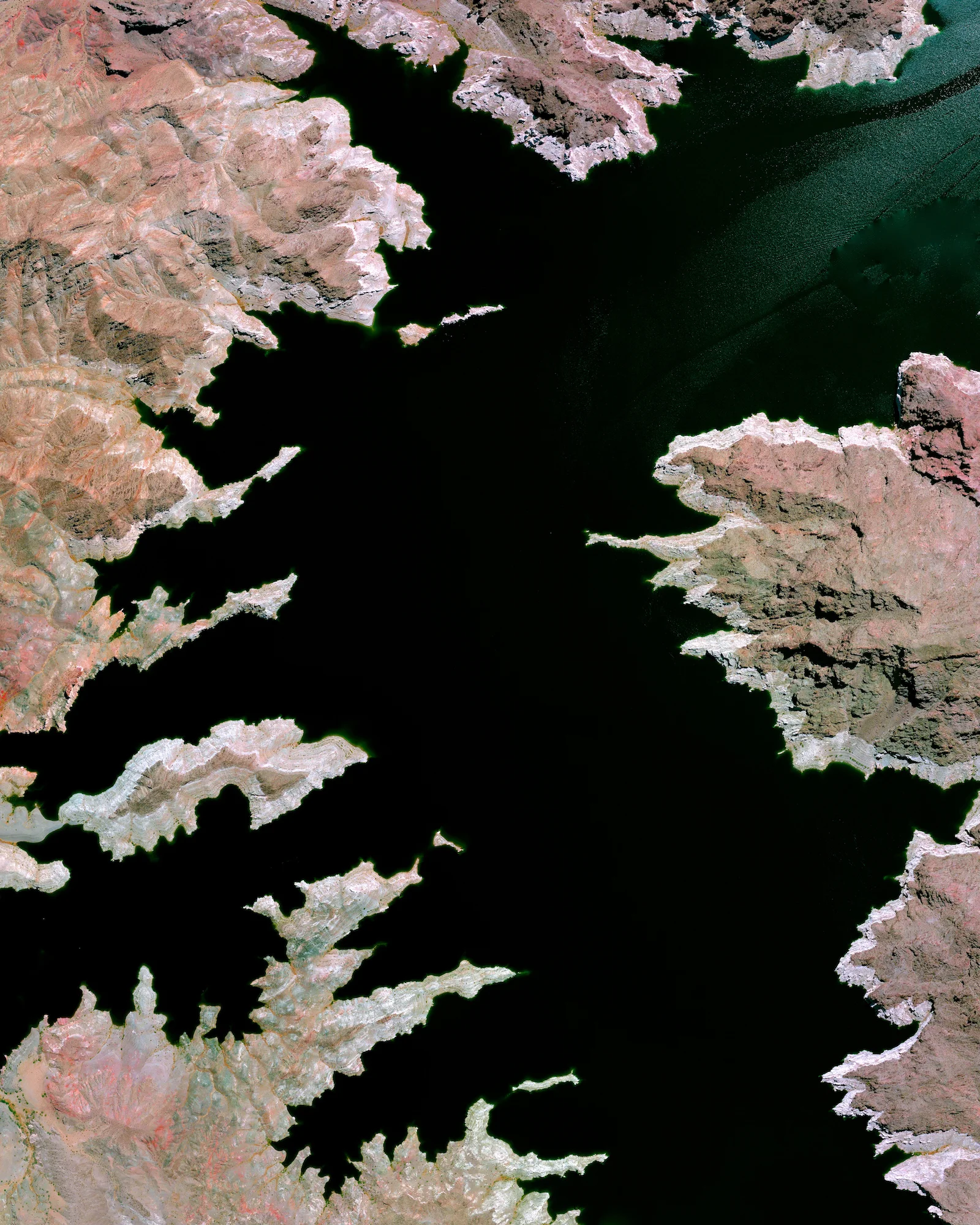 Lake Mead — located on the Colorado River 24 miles (38 km) southeast of Las Vegas, Nevada — is the largest reservoir in the United States. The lake was formed with the creation of the Hoover Dam in the 1930s. Due to a combination of drought and increased water demand in the surrounding states (specifically California, Nevada, New Mexico, and Arizona) the lake’s water level has been lowering drastically in recent years. This decreasing water level exposes the white shoreline that is visible in this Overview. 36°15'00.0"N, 114°23'24.0"W Source imagery: DigitalGlobe