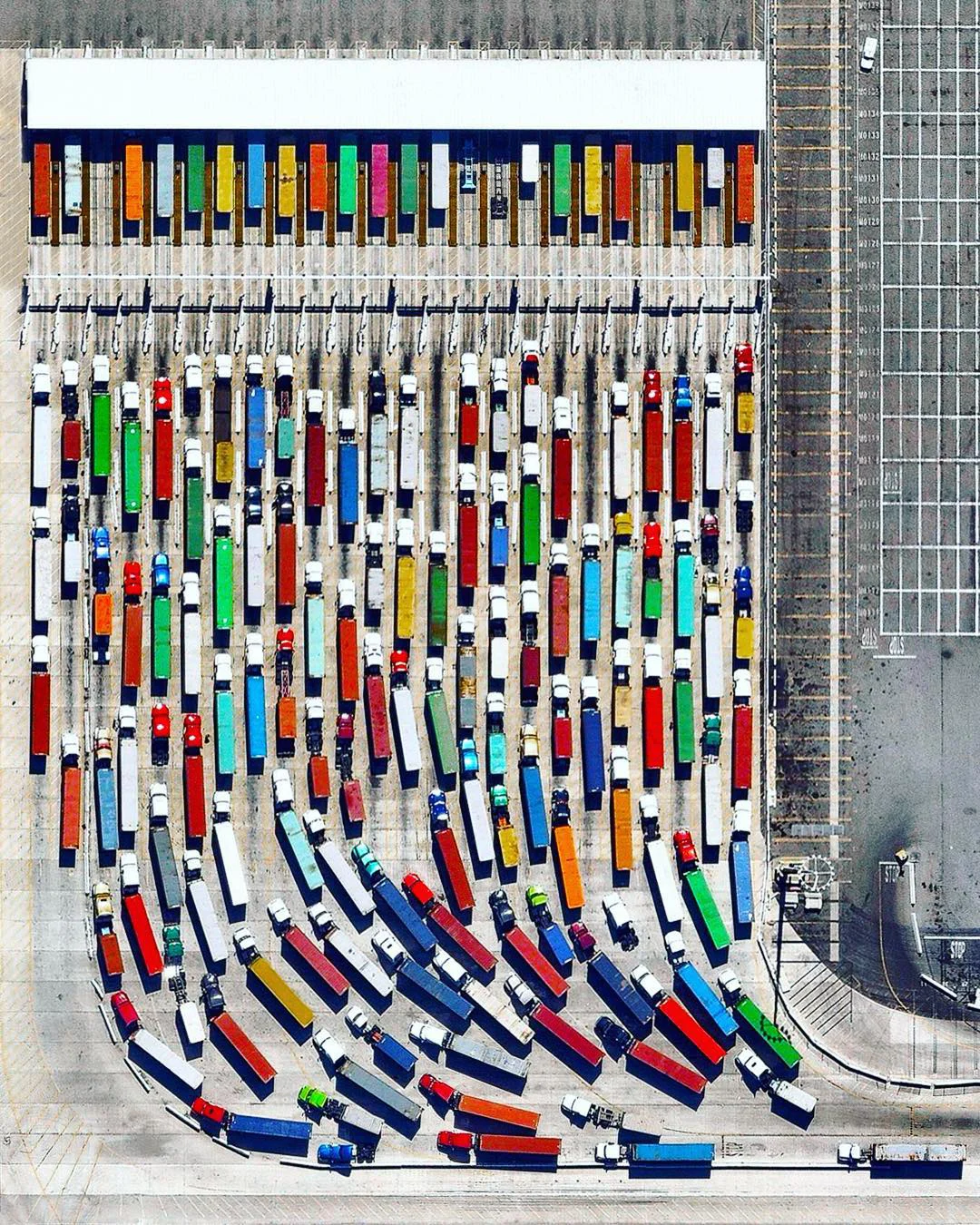 Long-haul trucks wait in line to exit the Port of Los Angeles in California. It is estimated that there are approximately 3.5 million truck drivers in the United States and they drive nearly 140 billion miles on American highways every year. In total, 433 billion miles are covered annually by the entire population. 33°43'43.0"N, 118°14'25.2"W Source imagery: Nearmap