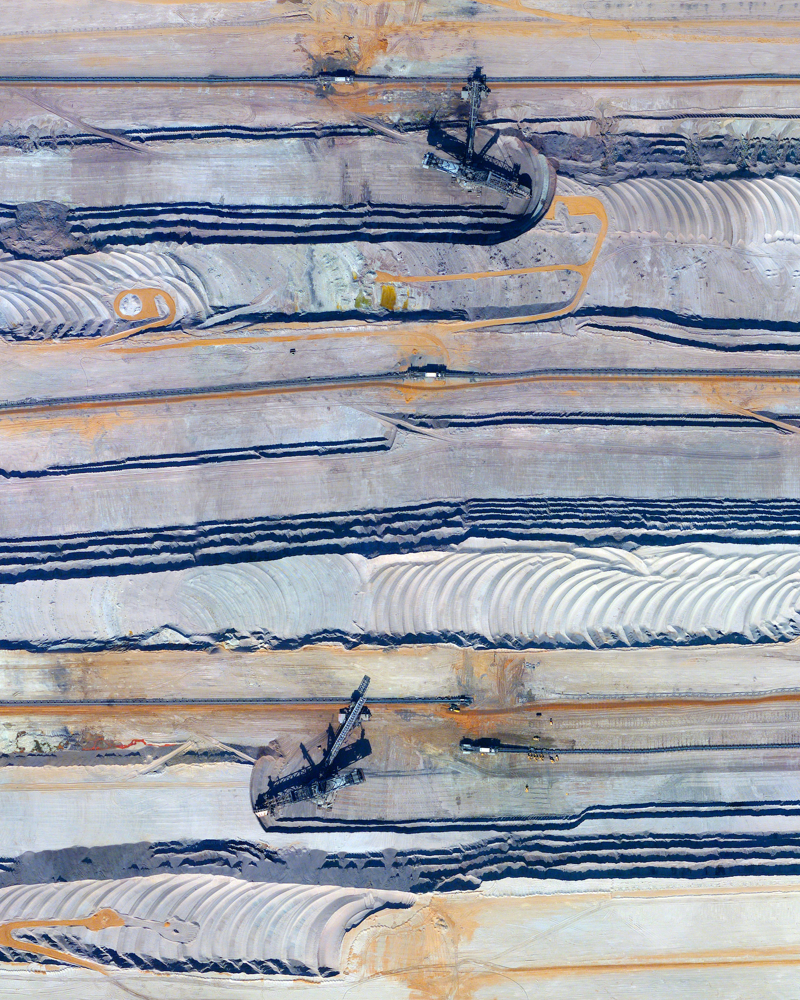 This Overview captures bucket-wheel excavators at the Tagebau Hambach open-pit mine in Niederzier and Elsdorf, Germany. These massive machines (up to 315 feet tall and 730 feet long) continuously scoop materials from the surface in order to extract lignite. Lignite, often referred to as “brown coal,” is a soft combustible sedimentary rock that is formed from naturally compressed peat and is used as a fuel for steam-electric power generation. 50°54'39.0"N, 6°30'10.0"E Source imagery: DigitalGlobe