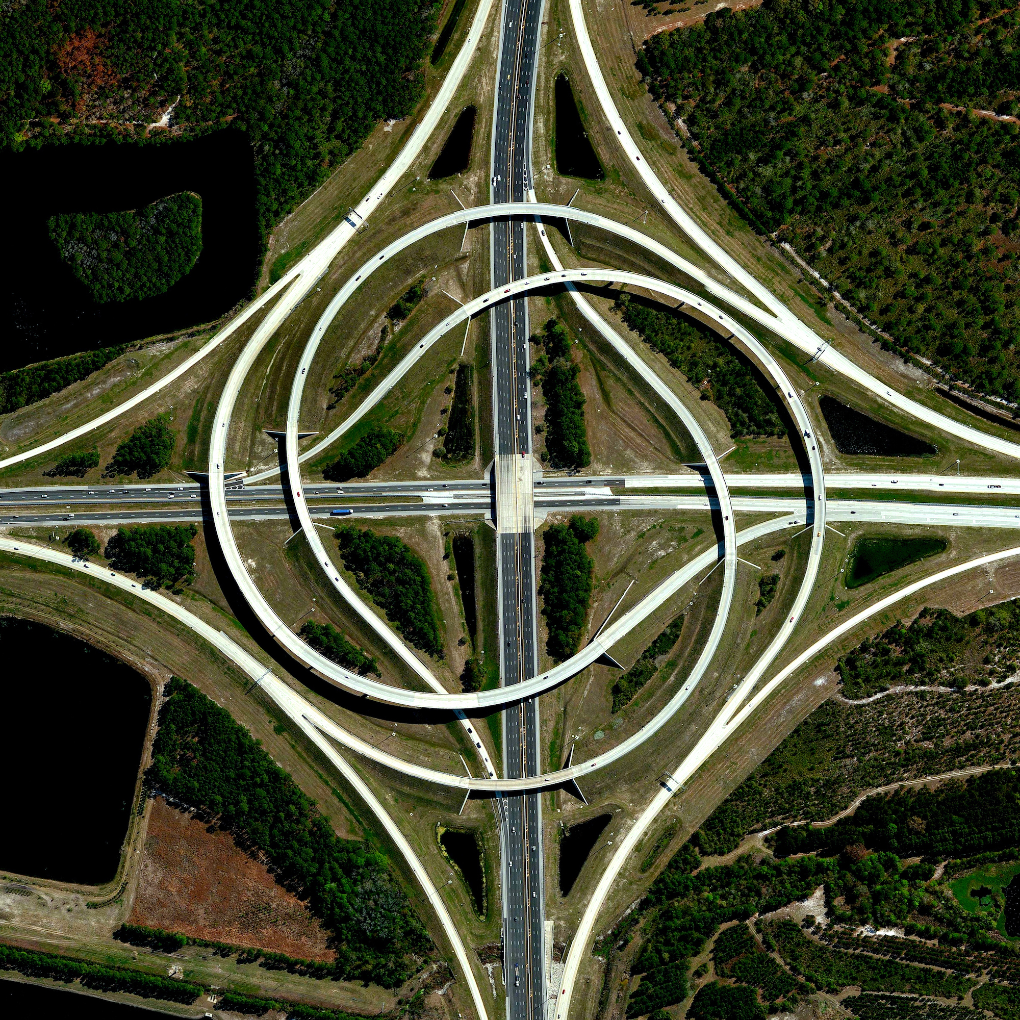 A turbine interchange connects the SR 9A and SR 202 in Jacksonville, Florida, USA. Also known as a whirlpool interchange, this structure consists of left-turning ramps sweeping around a center interchange, thereby creating a spiral pattern of right-hand traffic. This type of junction is rarely built, due to the vast amount land that is required to construct the sweeping roads. 30°15'11.0"N 81°30'58.3"W Source imagery: DigitalGlobe