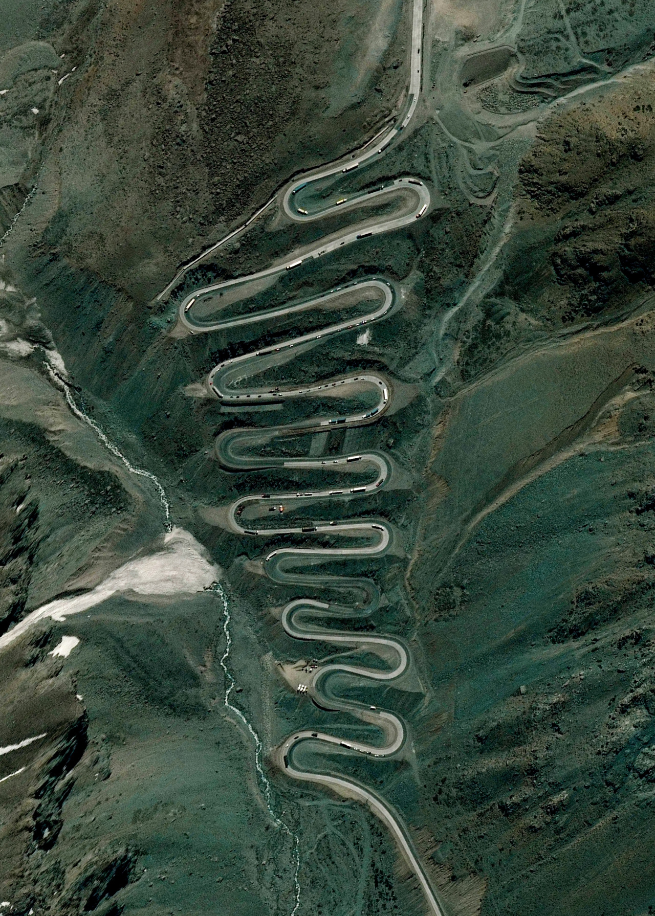 Los Caracoles Pass — or "The Snail's Pass" — is a twisting mountain road located in a remote section of the Andes Mountains on the Chilean side of the border with Argentina. The path climbs to an elevation of 10,419 feet (3,175 m), has no roadside safety barriers, and is frequented by large trucks. 32°51'27.0"S 70°08'35.4"W Source imagery: Maxar Technologies