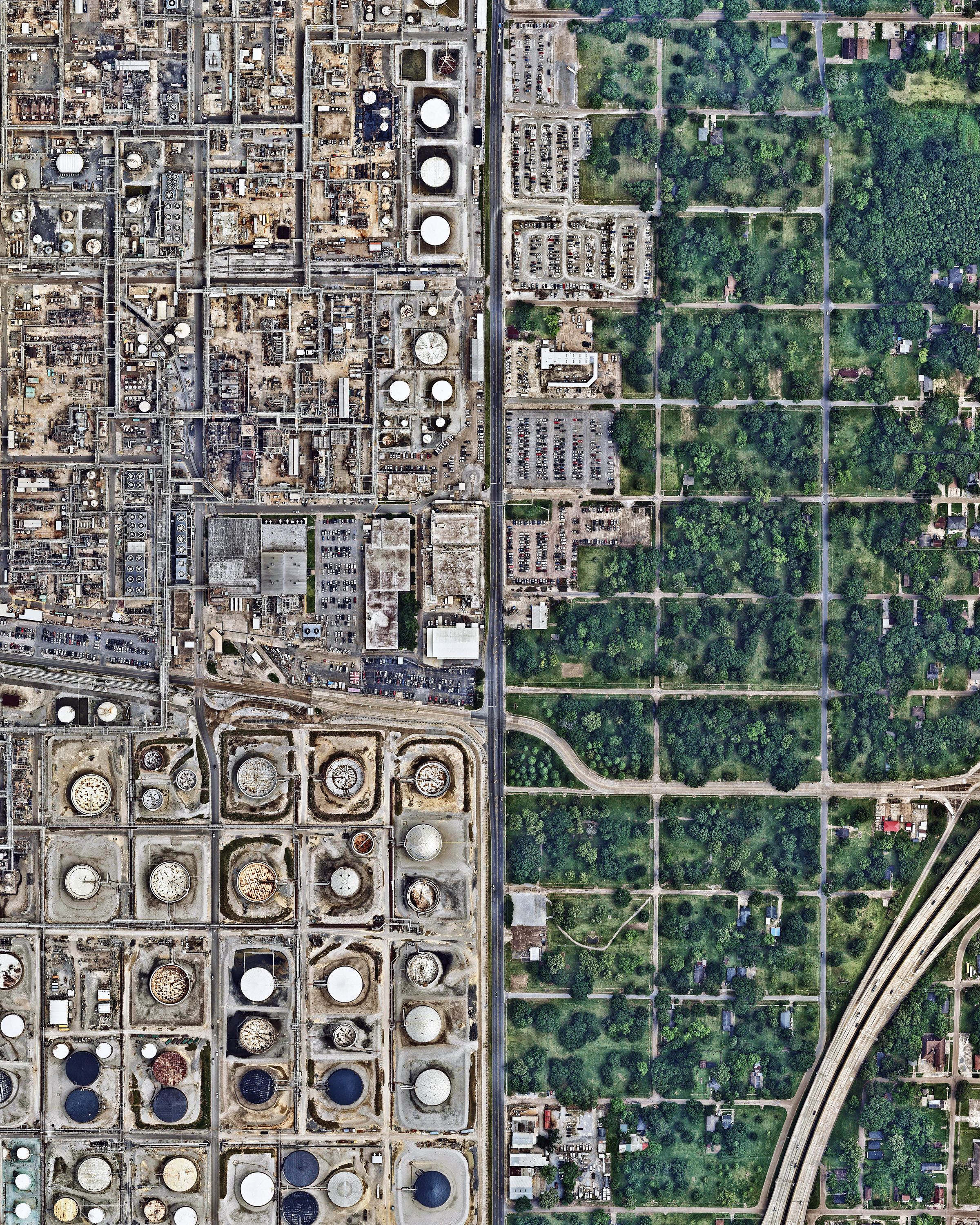 A residential neighborhood sits adjacent to a large oil refinery in Baton Rouge, Louisiana. Owned by ExxonMobil, this facility is the fourth largest of its kind in the United States and the 12th largest in the world, with an input capacity of more than 502,000 barrels per day. This refinery is one of many industrial plants along the Mississippi River between Baton Rouge and New Orleans, an 85-mile stretch known as "Cancer Alley" because of the abundance of cancer cases that have occurred there. 30°29'01.0"N 91°10'50.0"W Source imagery: Nearmap