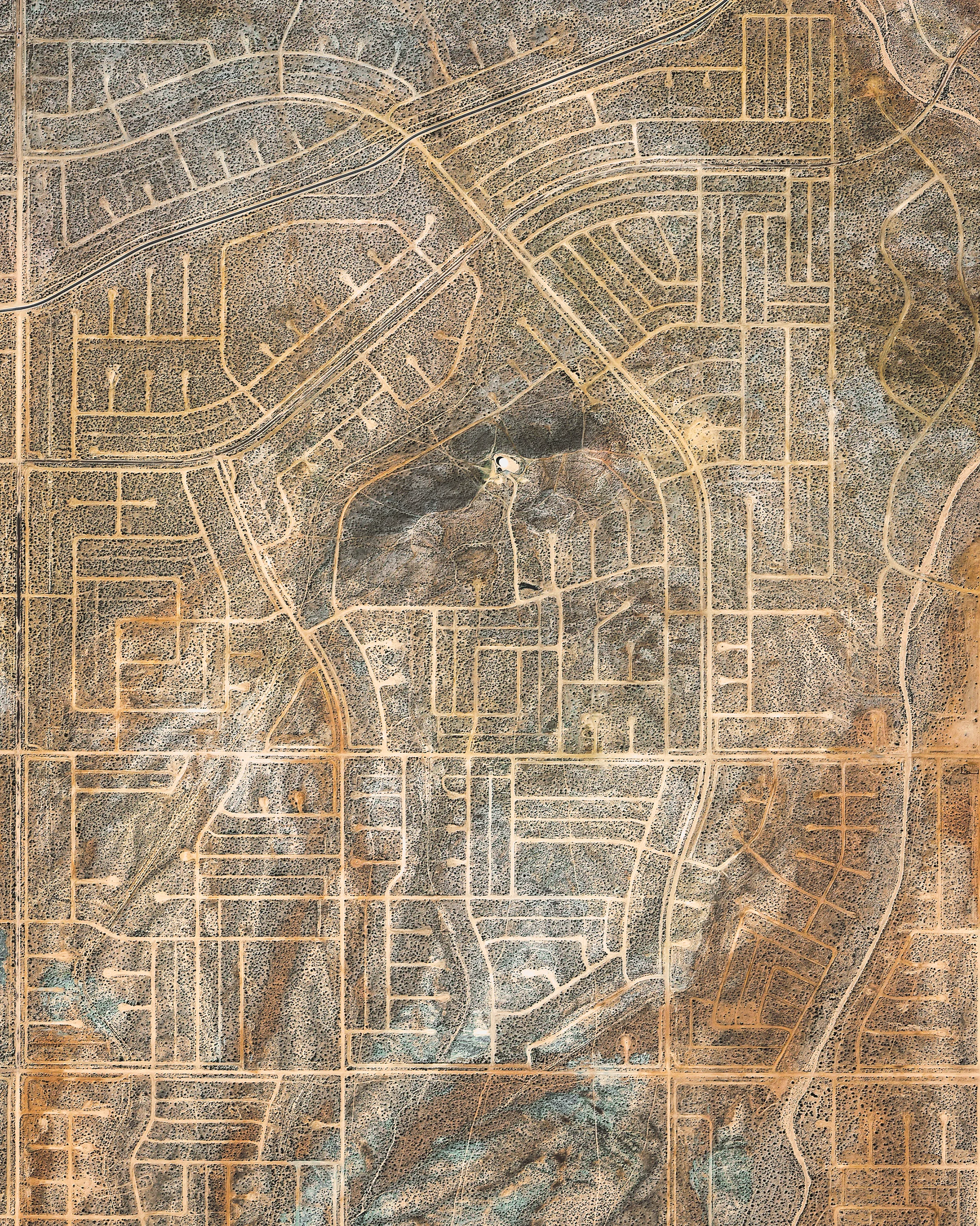 A network of vacant roads criss-crosses through California City, California. Incorporated in 1965, the city was originally designed to rival Los Angeles in size but fell far short of expectations, leaving behind a vast grid of crumbling paved roads. Though it is the third-largest city in California by area, at 203 square miles (527 square km), it is home to only about 14,200 people. 35.102385°, -117.938419° Source imagery: Maxar Technologies