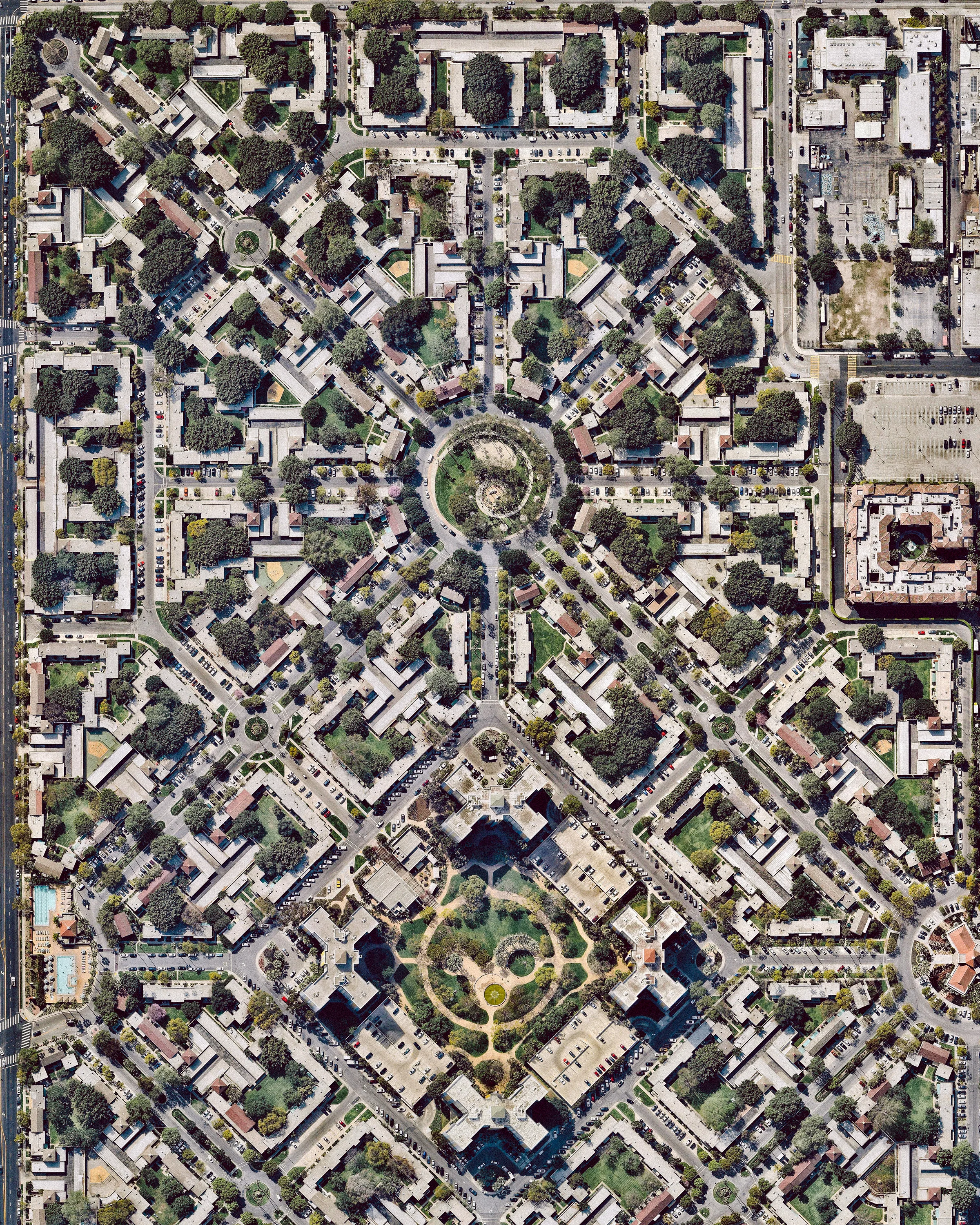 Park La Brea is a sprawling apartment community in the Miracle Mile District of Los Angeles, California. With 4,255 units located in 18 thirteen-story towers and 31 two-story "garden apartment buildings,” it is the largest housing development in the U.S. west of the Mississippi River. Inspired by the innovative housing of Le Corbusier in Paris, the 160-acre (0.65 square km) neighborhood features square-block sized formations of town houses surrounding shared green spaces. 34.067652°, -118.355662° Source imagery: Nearmap