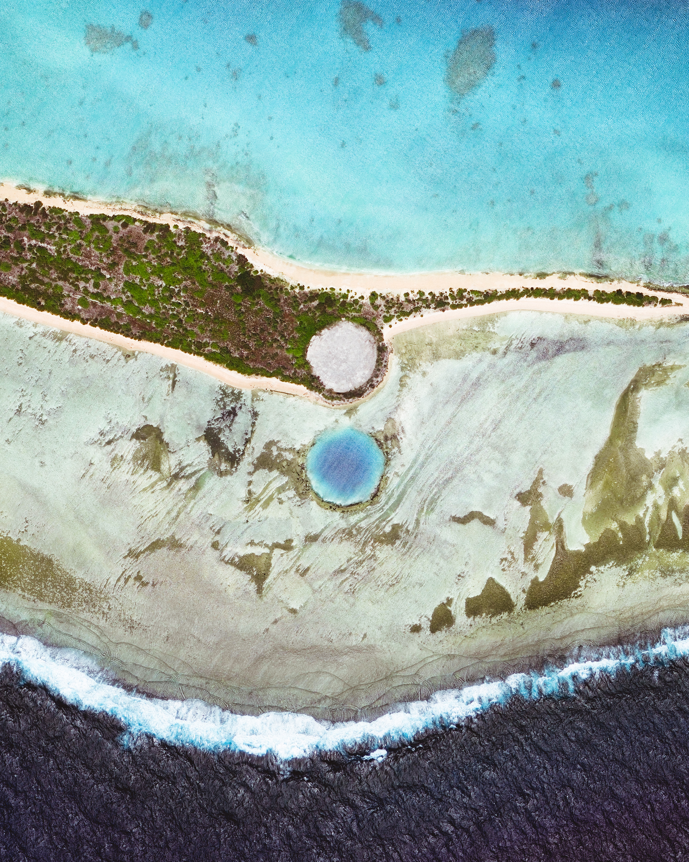 Cactus Dome is a concrete structure built over a nuclear crater on Runit Island in the Marshall Islands. Debris inside the crater comes from six nearby islands, where the United States performed nuclear tests between 1946 and 1958. The dome, known locally as "The Tomb," is 377 feet (115 m) in diameter, 18 inches (46 cm) thick, and encapsulates an estimated 95,000 cubic yards (73,000 cubic m) of radioactive debris. 11.552439°, 162.347180° Source imagery: Maxar Technologies