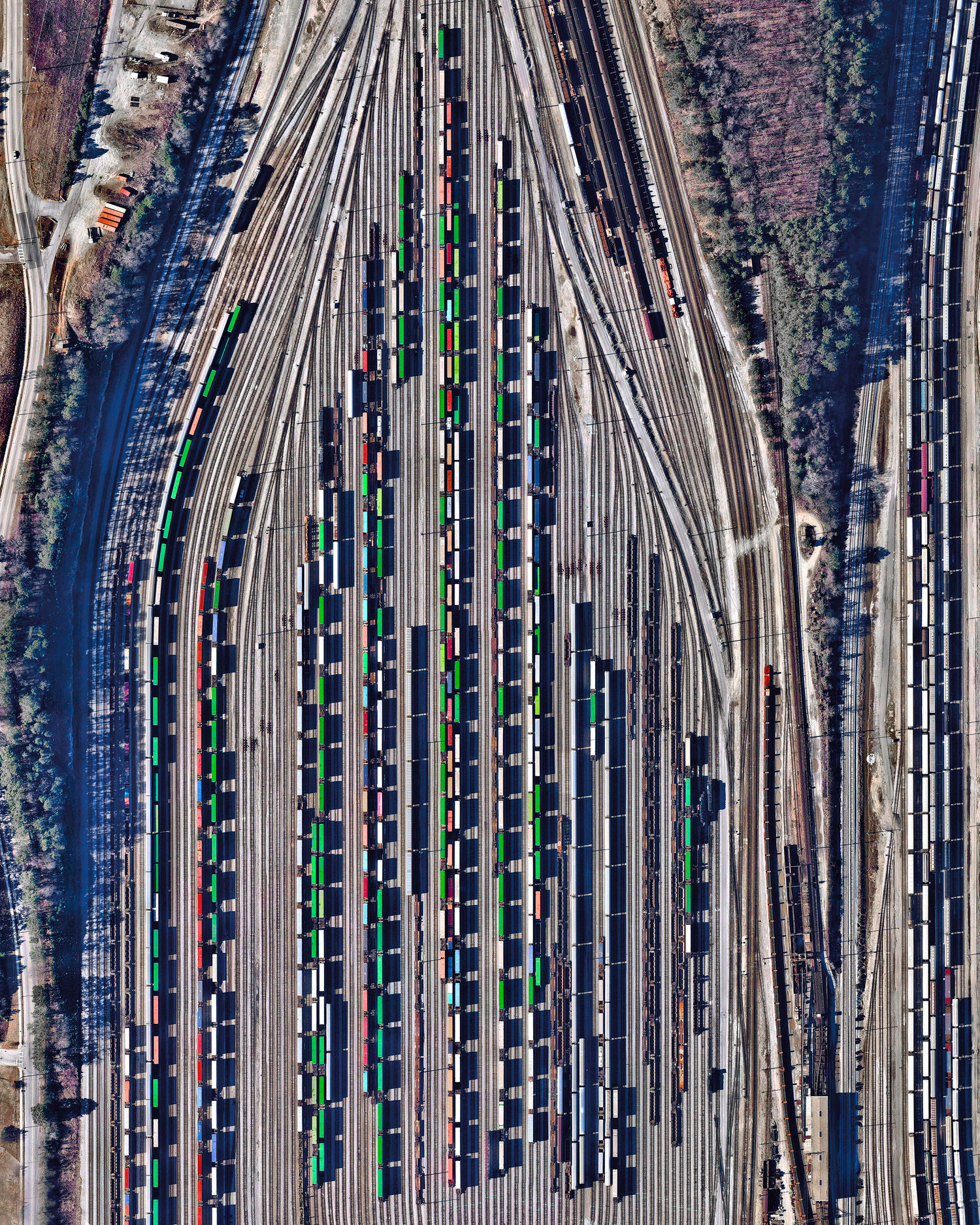 Freight train cars, casting long shadows, are seen in at Inman Yard in Atlanta, Georgia, USA. The facility is operated by Norfolk Southern and serves as one of the major freight hubs on its network that extends for more than 36,000 miles (57,936 km) in the United States. 33.795750°, -84.444583° Source imagery: Nearmap