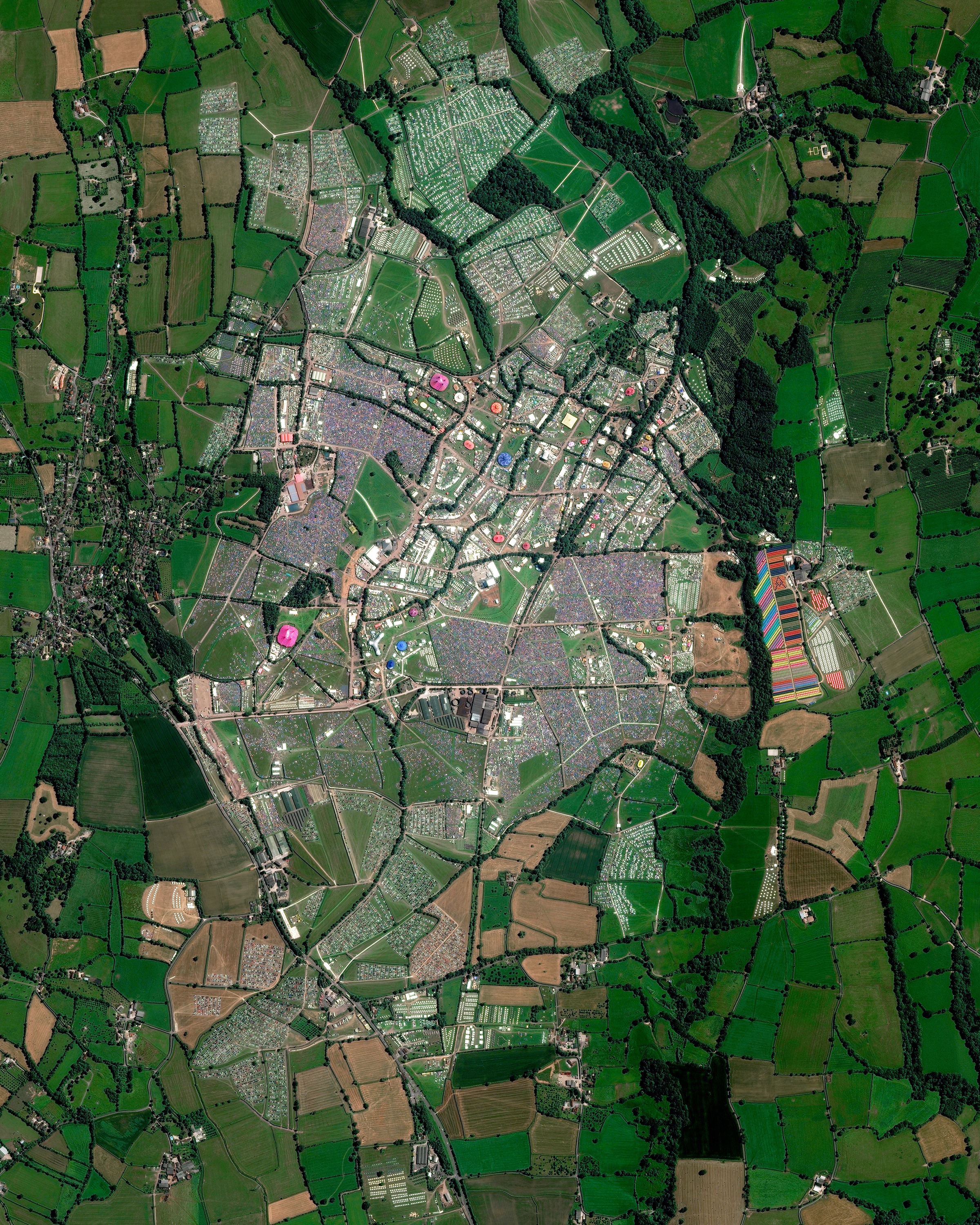 This Overview captures the 2017 Glastonbury Festival in Pilton, England. The annual, five-day music event was attended by more than 135,000 people. Concert-goers are provided a campsite at the venue but must bring their own tents — which vividly dot the landscape in this Overview. The population of Pilton on the other 360 days of the year is 998. 51.152500°, -2.589722° Source imagery: Maxar Technologies