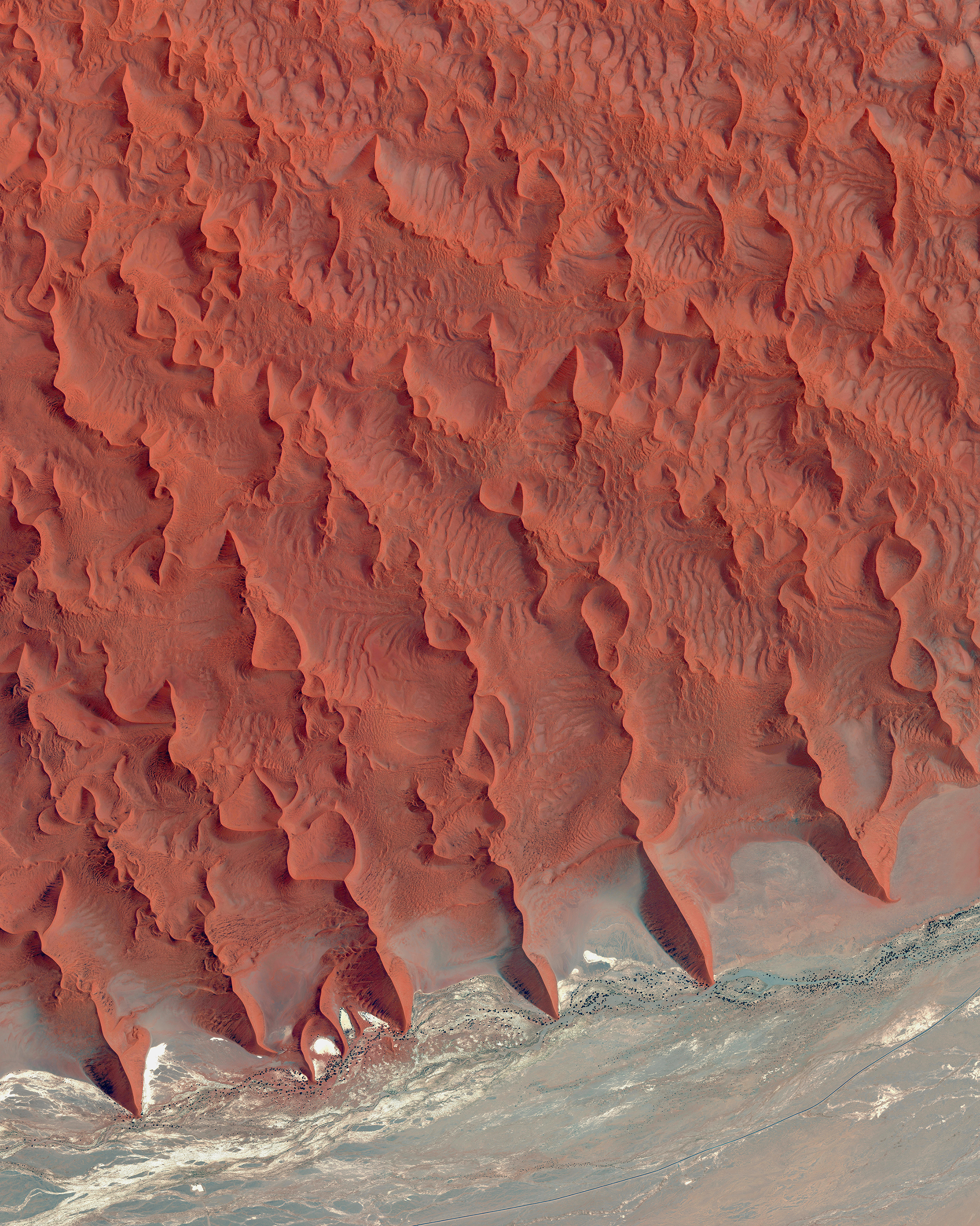 Sossusvlei is a salt and clay pan located on the edge of the Namib Desert in Namibia. The reddish sand dunes seen in the top half of this Overview are among the tallest in the world, with many rising more than 656 feet (200 meters). -24.733333°, 15.366667° Source imagery: Maxar Technologies