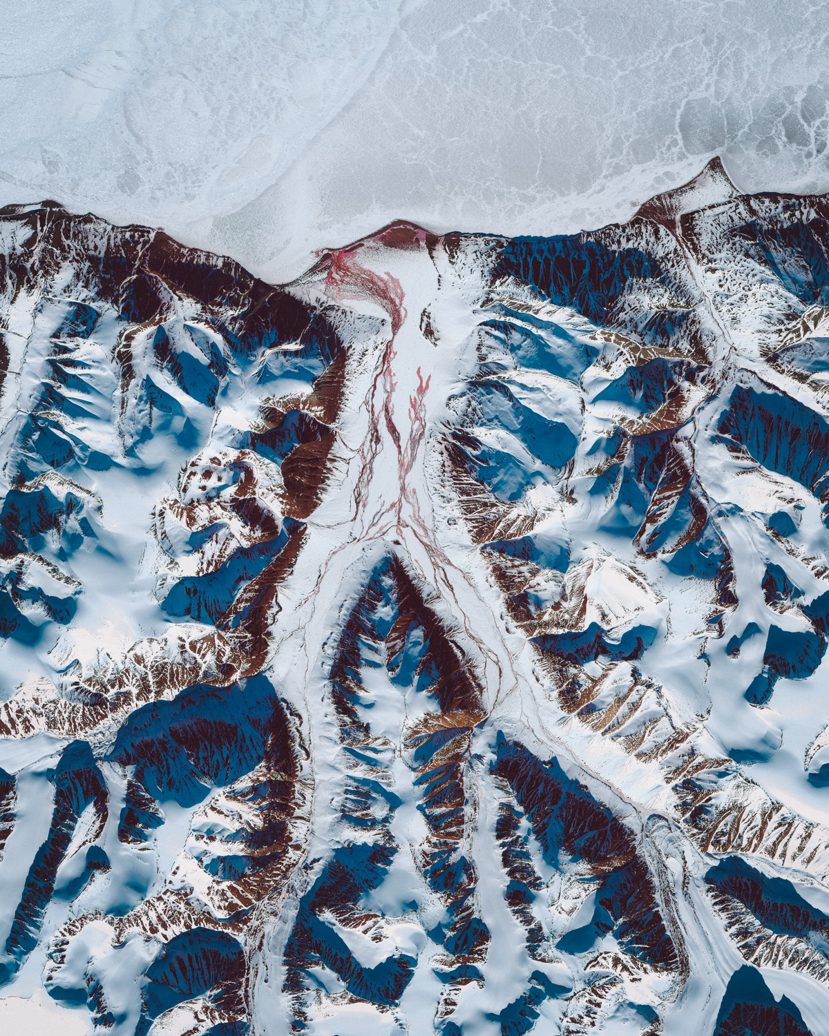 Frozen tributaries branch off the Scoresby Sund, a large fjord system on the east coast of Greenland. Its tree-like structure covers an area of approximately 14,700 square miles (38,000 square km), making it one of the largest and longest fjord systems in the world. At the mouth of the Scoresby Sund — roughly 125 miles southeast of this Overview — stands Ittoqqortoormiit, the only permanent settlement in the region with a population of about 450. 71.740400°, -25.834400° Source imagery: Maxar Technologies