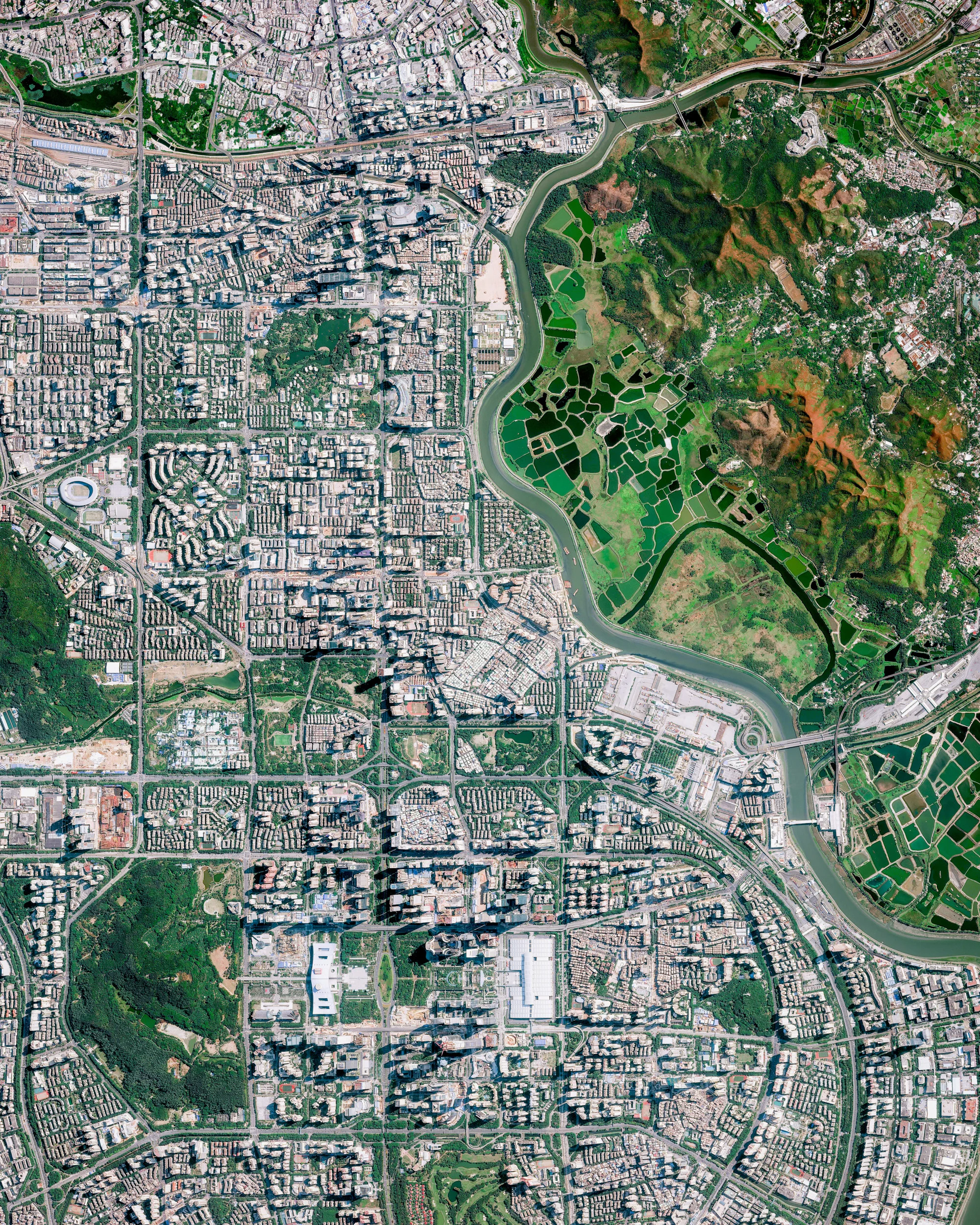 Shenzhen, China, was one of the fastest-growing cities in the world in the 1990s and 2000s and currently has a population of at least 12.5 million. Bordering Hong Kong to the south, Huizhou to the northeast, and Dongguan to the northwest, it is part of the Pearl River Delta megalopolis — one of the most densely urbanized regions in the world. Recently, along Shenzhen's border with Hong Kong, hundreds of Chinese security officers have gathered in a show of force as tensions rise between Hong Kong and mainland China. 22.550000°, 114.100000° Source imagery: Maxar Technologies