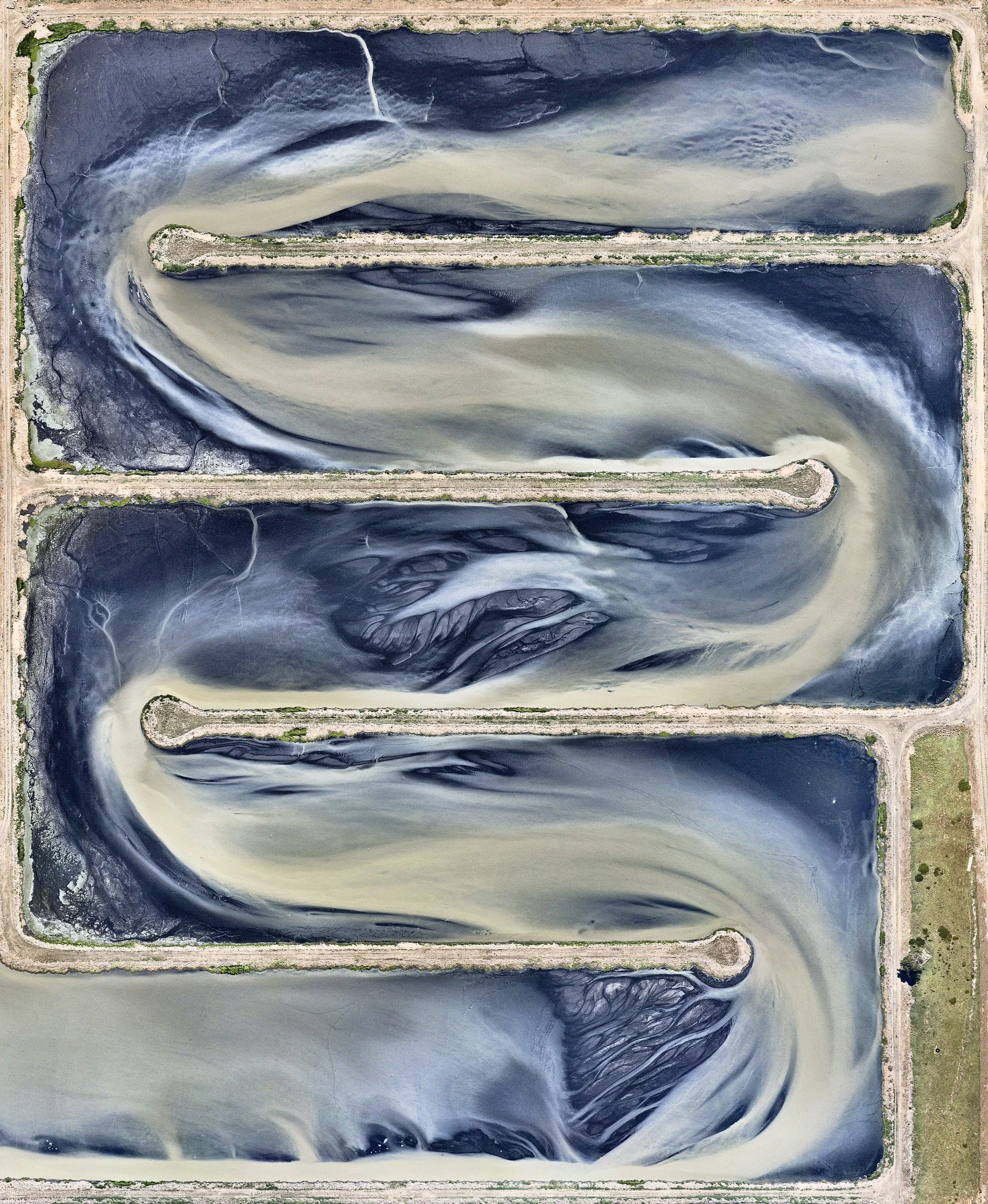 A sewage treatment pond is seen at the Western Treatment Plant in Cocoroc, Australia. This facility treats half of the sewage produced in the nearby city of Melbourne and is nearly 26,000 acres (10,500 hectares) in size — roughly equal to the total area of Disney World. The Western Treatment Plant produces 10.5 billion gallons (40 billion liters) of Class A water, the highest standard of recycled water. -37.985213°, 144.609568° Source imagery: Nearmap