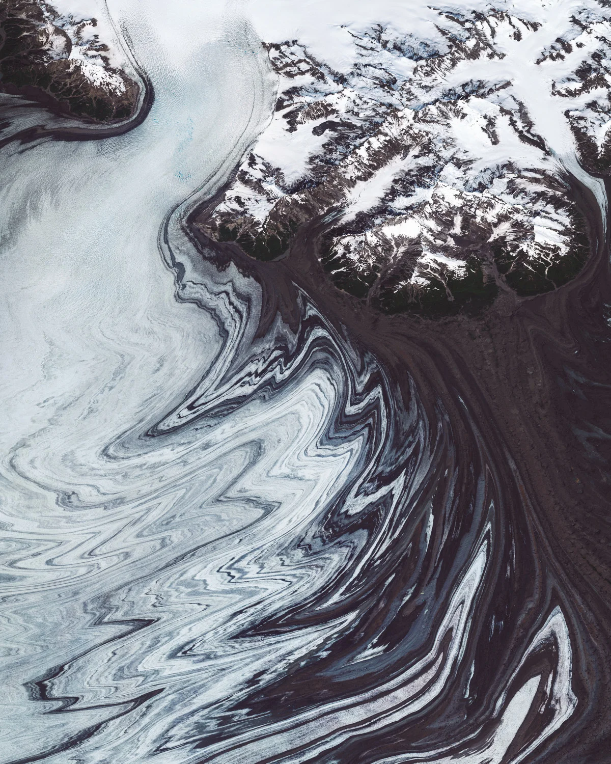 Glacial ice and debris form incredible patterns around the edges of the Malaspina Glacier in southeastern Alaska. Located at the head of the Alaska Panhandle, the glacier is roughly 40 miles (65 km) wide and 28 miles (40 km) long, covering an area of about 1,500 square miles (3,900 square km). Decades of aerial photographs and radar data have shown that the Malaspina Glacier lost about 66 feet (20 m) of thickness between 1980 and 2000 — enough shrinkage to contribute 0.5% of the rise in global sea level. 60.001700°, -140.386000° Source imagery: Maxar Technologies