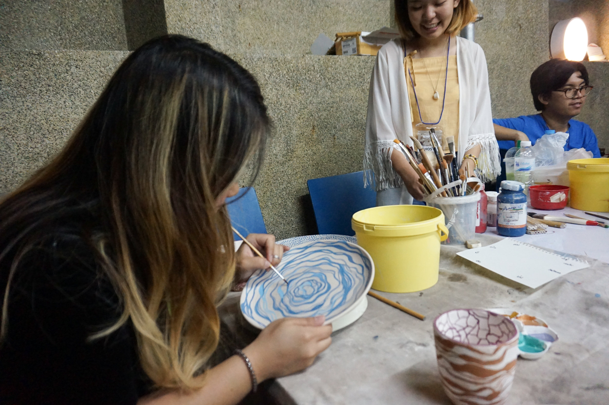 Earn is painting her 8" stoneware plate.