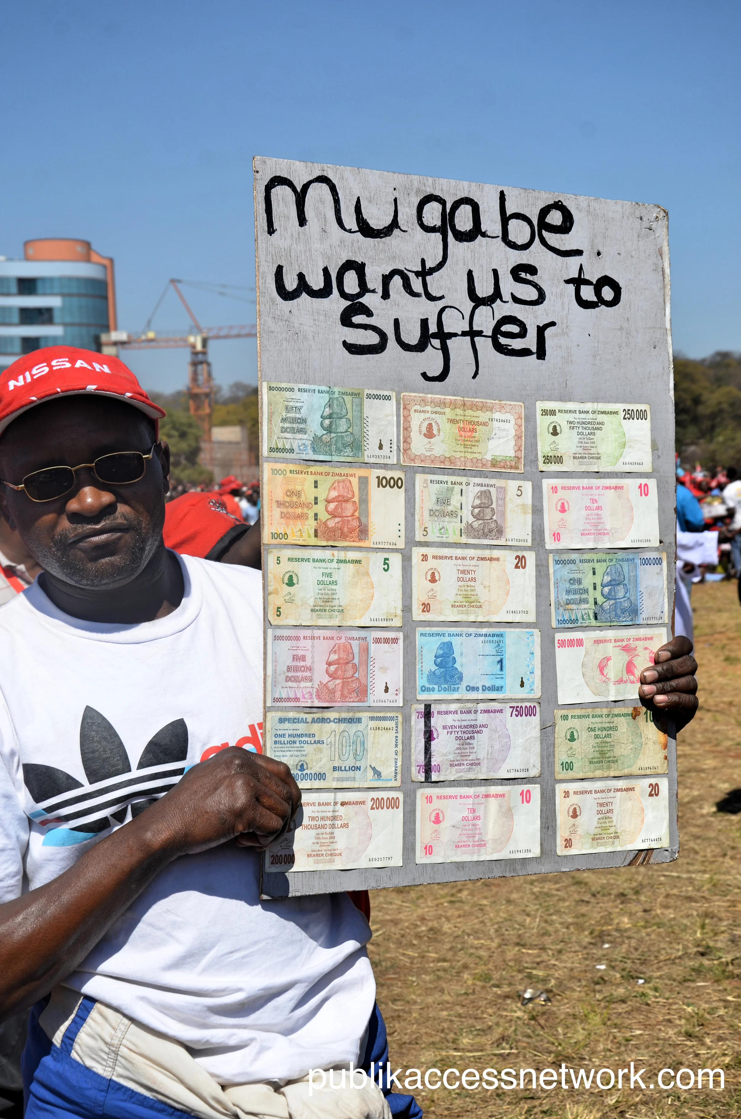 A man holding a Zimbabwean dollar 'mosaic' reminiscent of the pre2009 hyper inflation.