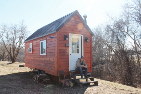 Luke in front of his tiny house.