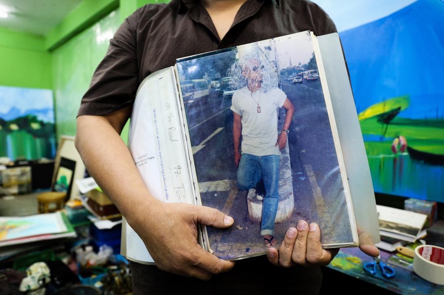 Myanmar artist Nyein Chan Su holds a photo taken of him during a performance art piece in 1997, when General Than Shwe's was head of the SLORC. Yangon, Myanmar.