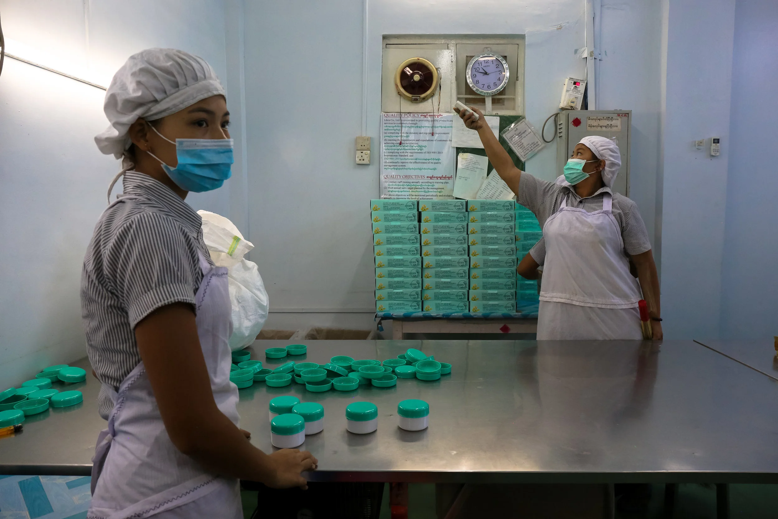 Keepin' cool. Thanaka factory workers pack and seal jars of ready-made thanaka to be shipped across the country.