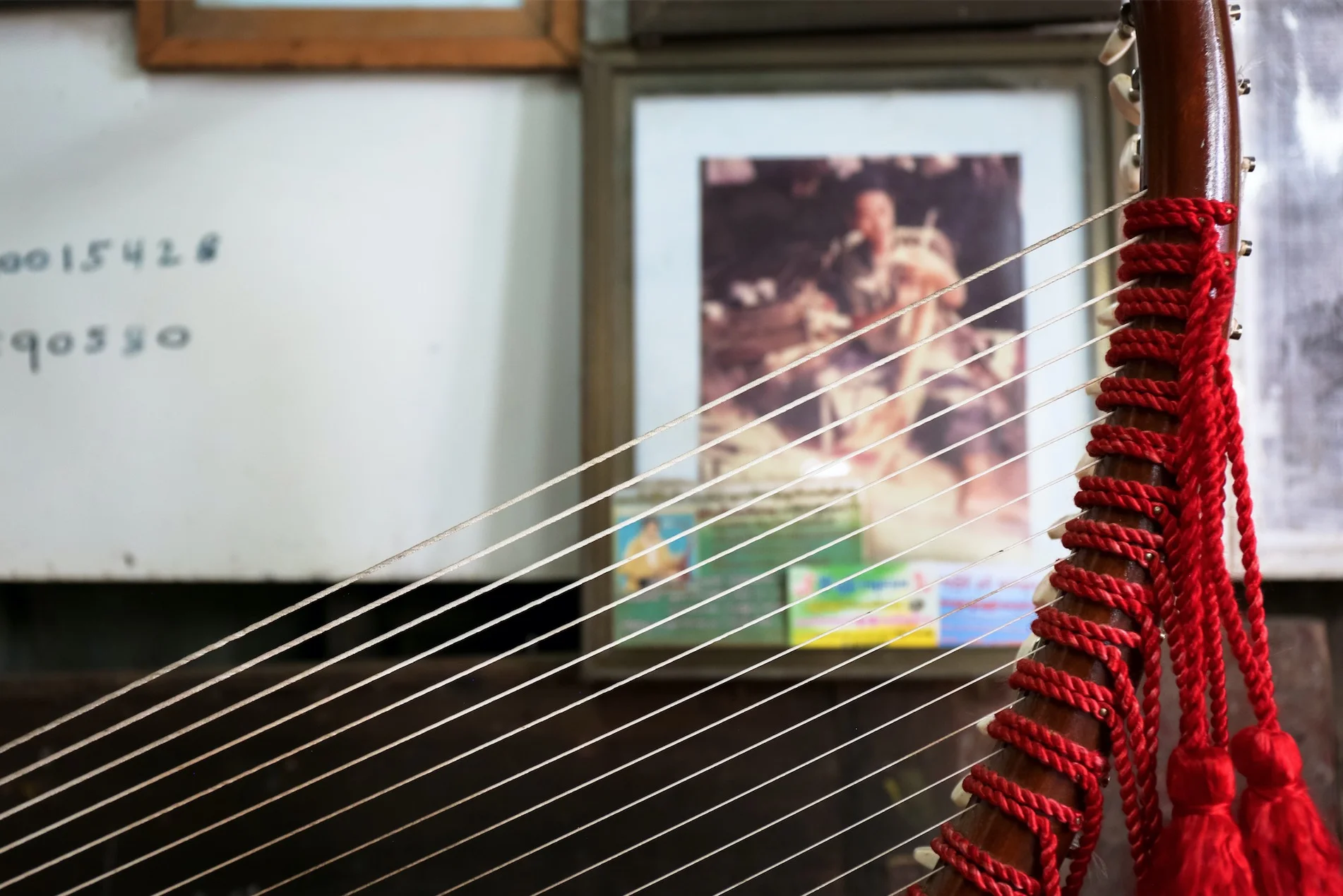 Portraits of Aye Aung Win's family, harp-buyers, and other celebrities his family has met line the walls of his studio. July 2017