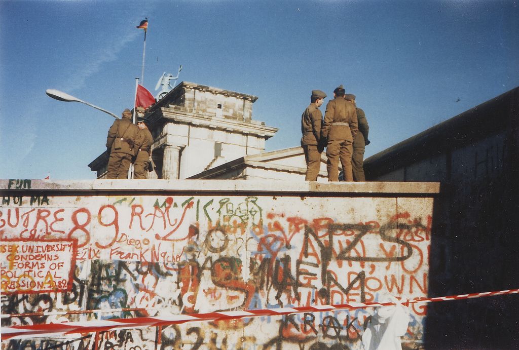 Soldiers standing on top of the Berlin Wall on Nov. 16, 1989. Image from Wikimedia Commons. 