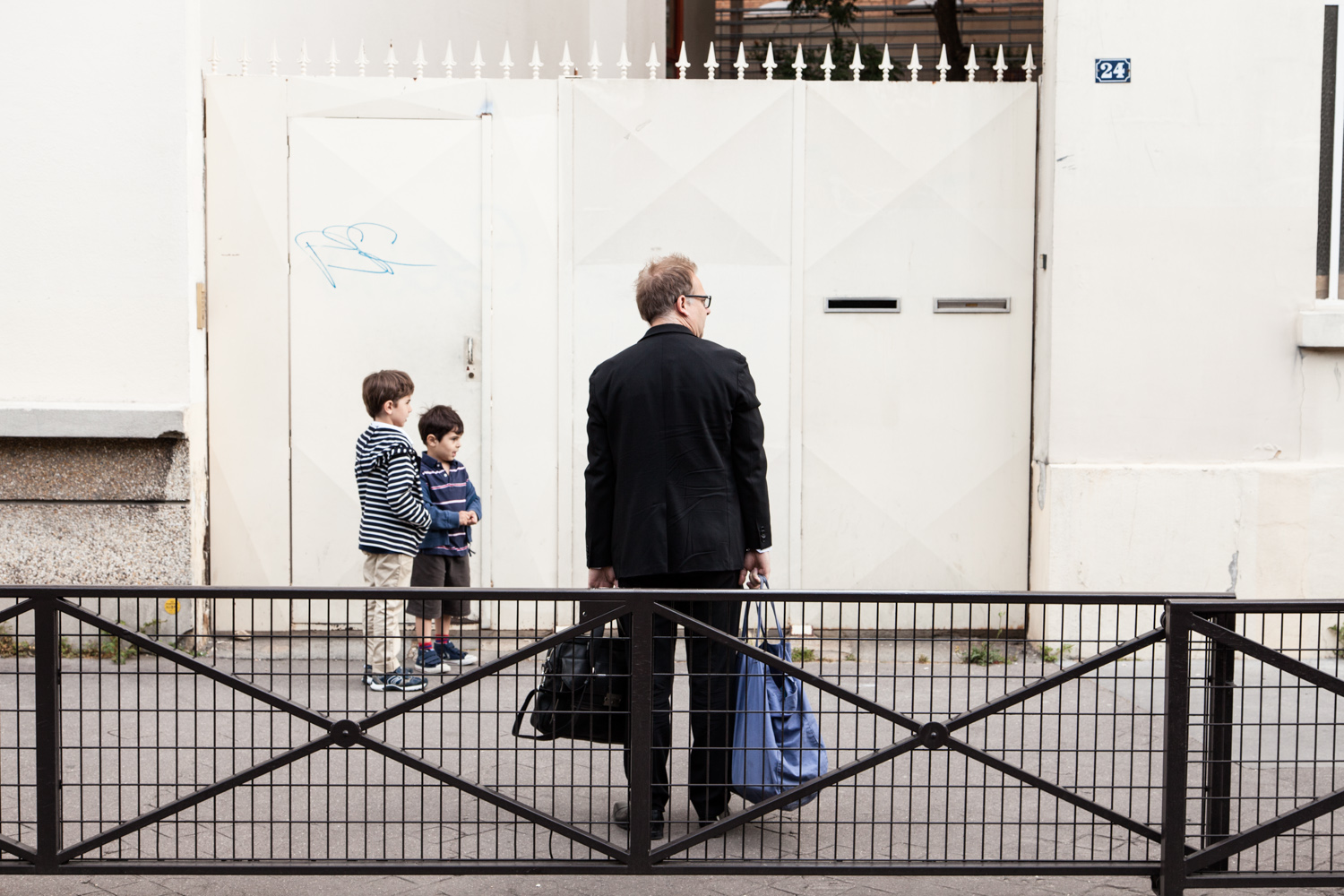  Un père attend l'ouverture de l'école. École aujourd'hui, Paris.  Commande pour Télérama. 