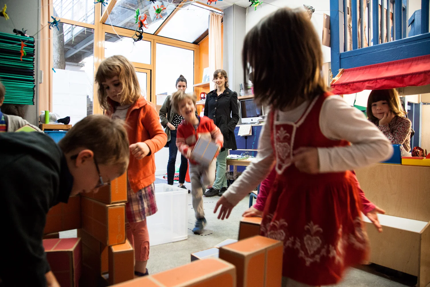 Des enfants jouent sous le regard de leurs mères venues les déposer. École aujourd'hui, Paris. Commande pour Télérama.