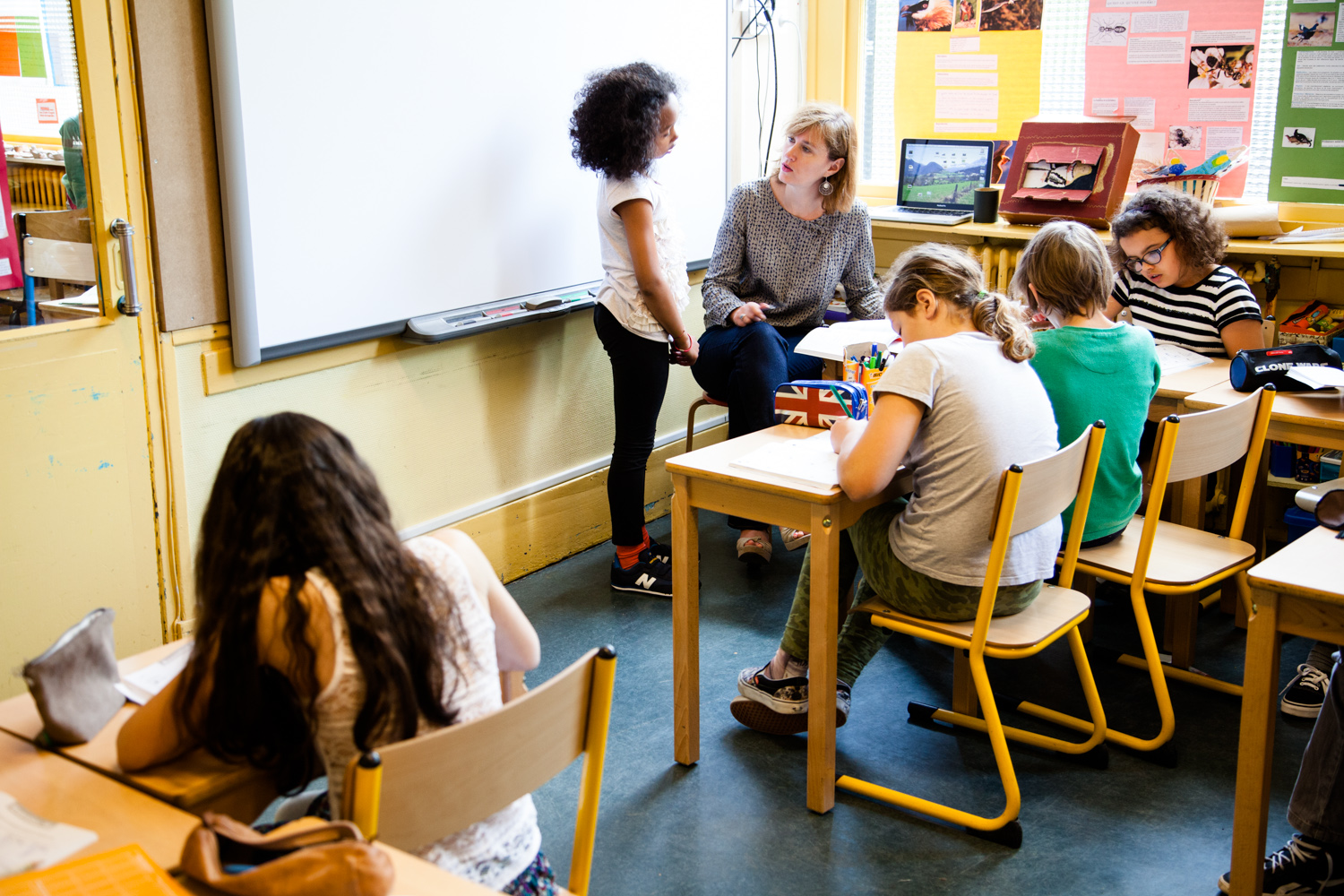  Des écoliers montrent leurs travaux à la maîtresse. École aujourd'hui, Paris.  Commande pour Télérama. 