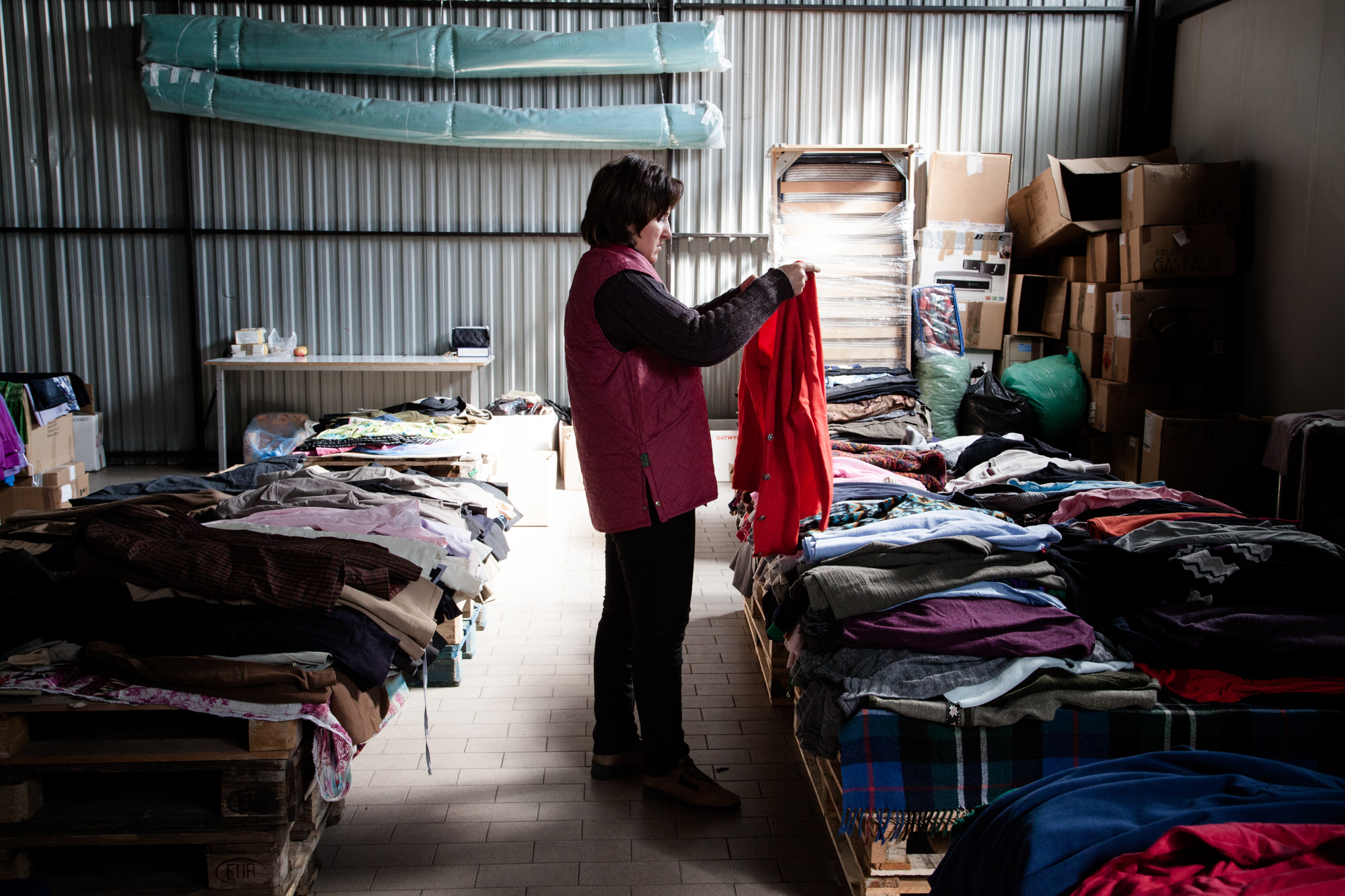 Dans un des hangars, une employée trie les dons reçus par l'hôpital. Les vêtements sont distribués aux habitants de la région. C'est pour beaucoup un des seuls moyen de s'habiller. 